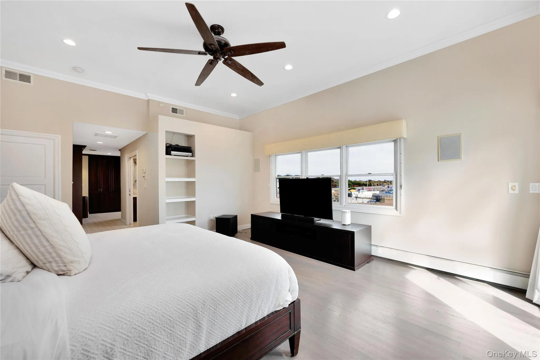 Bedroom with ornamental molding, a baseboard heating unit, recessed lighting, ceiling fan, and light wood finished floors Bedroom with ornamental molding, a baseboard heating unit, recessed lighting, ceiling fan, and light wood finished floors