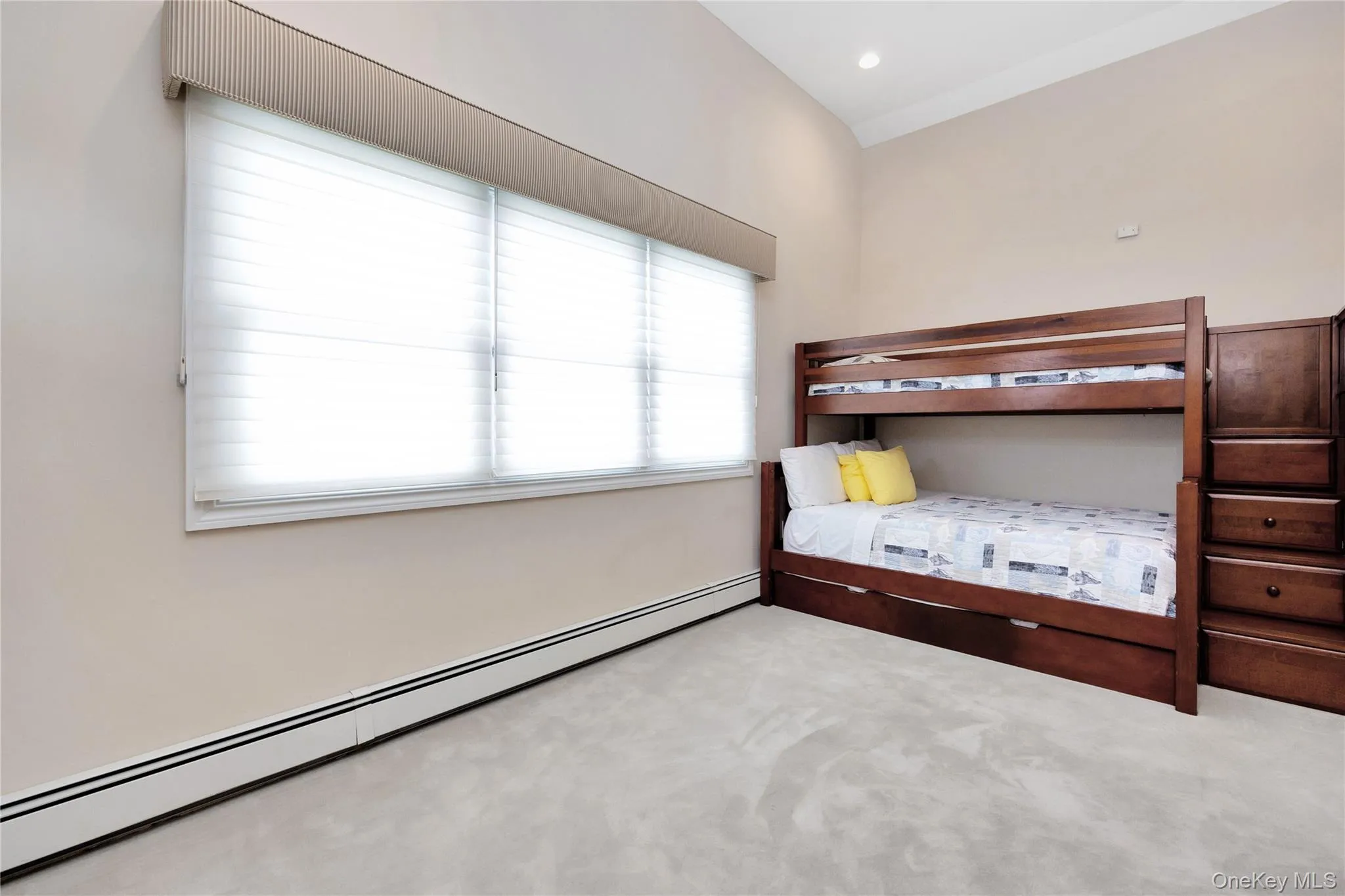 Carpeted bedroom with a baseboard radiator and recessed lighting Carpeted bedroom with a baseboard radiator and recessed lighting