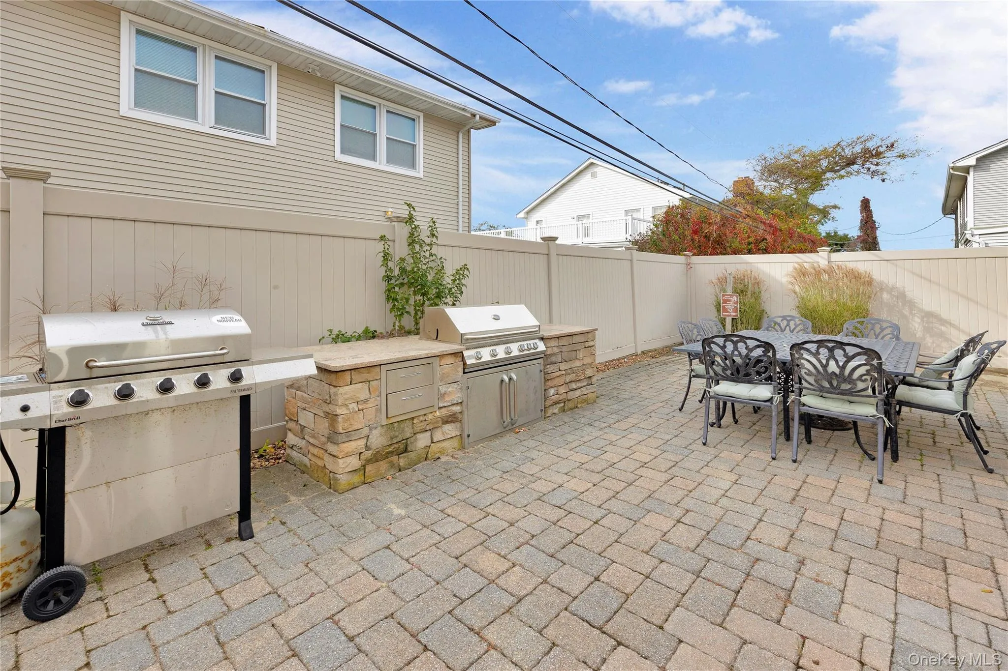 Fenced backyard with outdoor dining area, a patio, and an outdoor kitchen Fenced backyard with outdoor dining area, a patio, and an outdoor kitchen