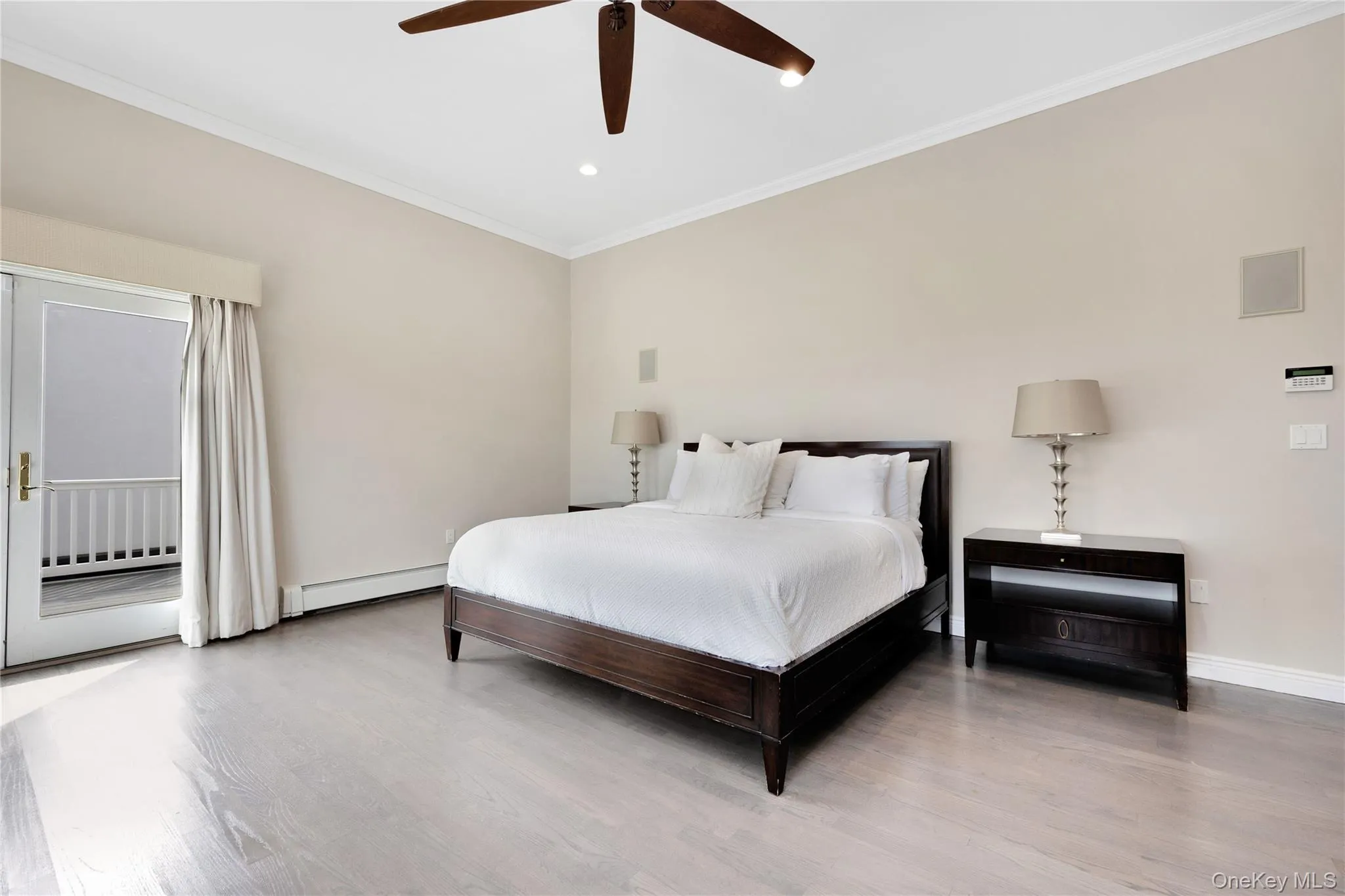 Bedroom featuring crown molding, access to outside, wood finished floors, a baseboard heating unit, and ceiling fan Bedroom featuring crown molding, access to outside, wood finished floors, a baseboard heating unit, and ceiling fan