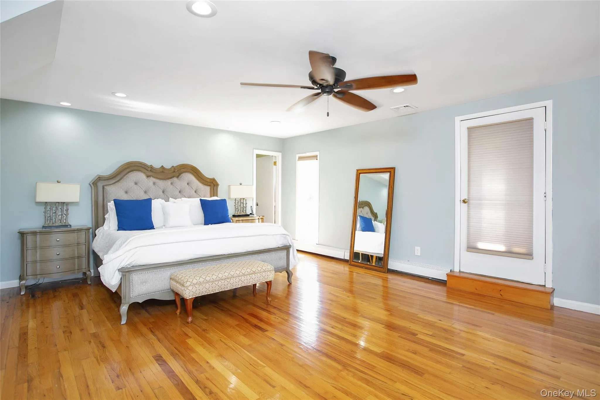 Bedroom with light wood-type flooring, ceiling fan, recessed lighting, and a baseboard radiator Bedroom with light wood-type flooring, ceiling fan, recessed lighting, and a baseboard radiator