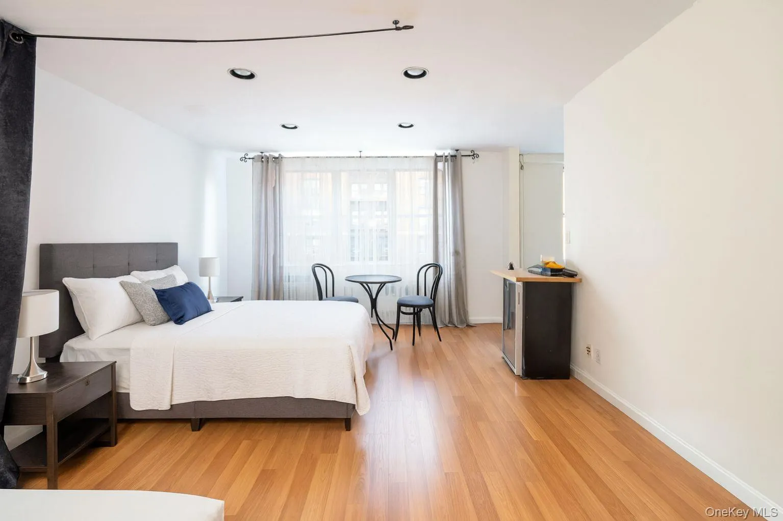 Virtually Staged Bedroom with light wood-style flooring and recessed lighting Virtually Staged Bedroom with light wood-style flooring and recessed lighting