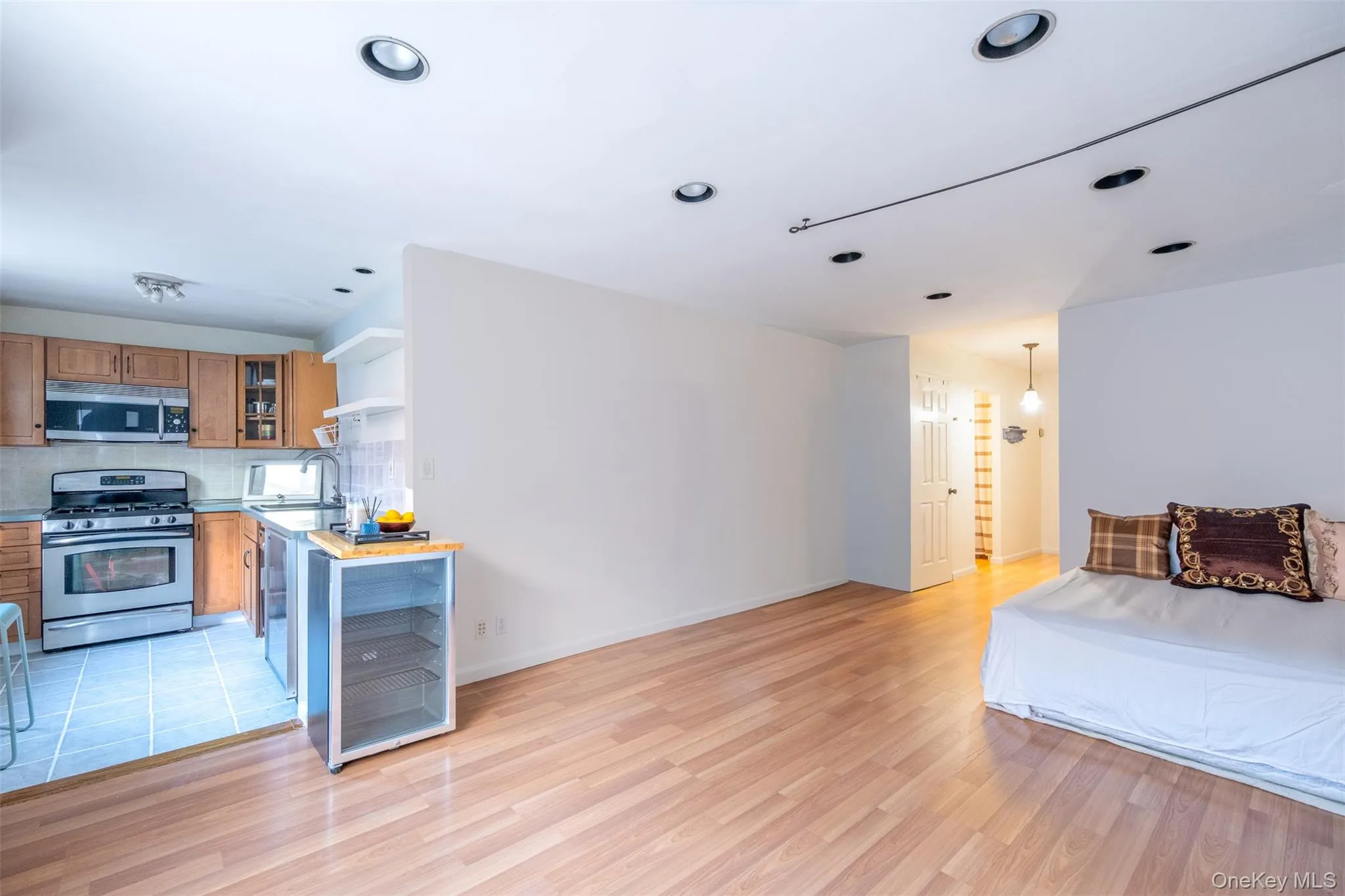 Bedroom featuring wine cooler, light wood-type flooring, and recessed lighting Bedroom featuring wine cooler, light wood-type flooring, and recessed lighting