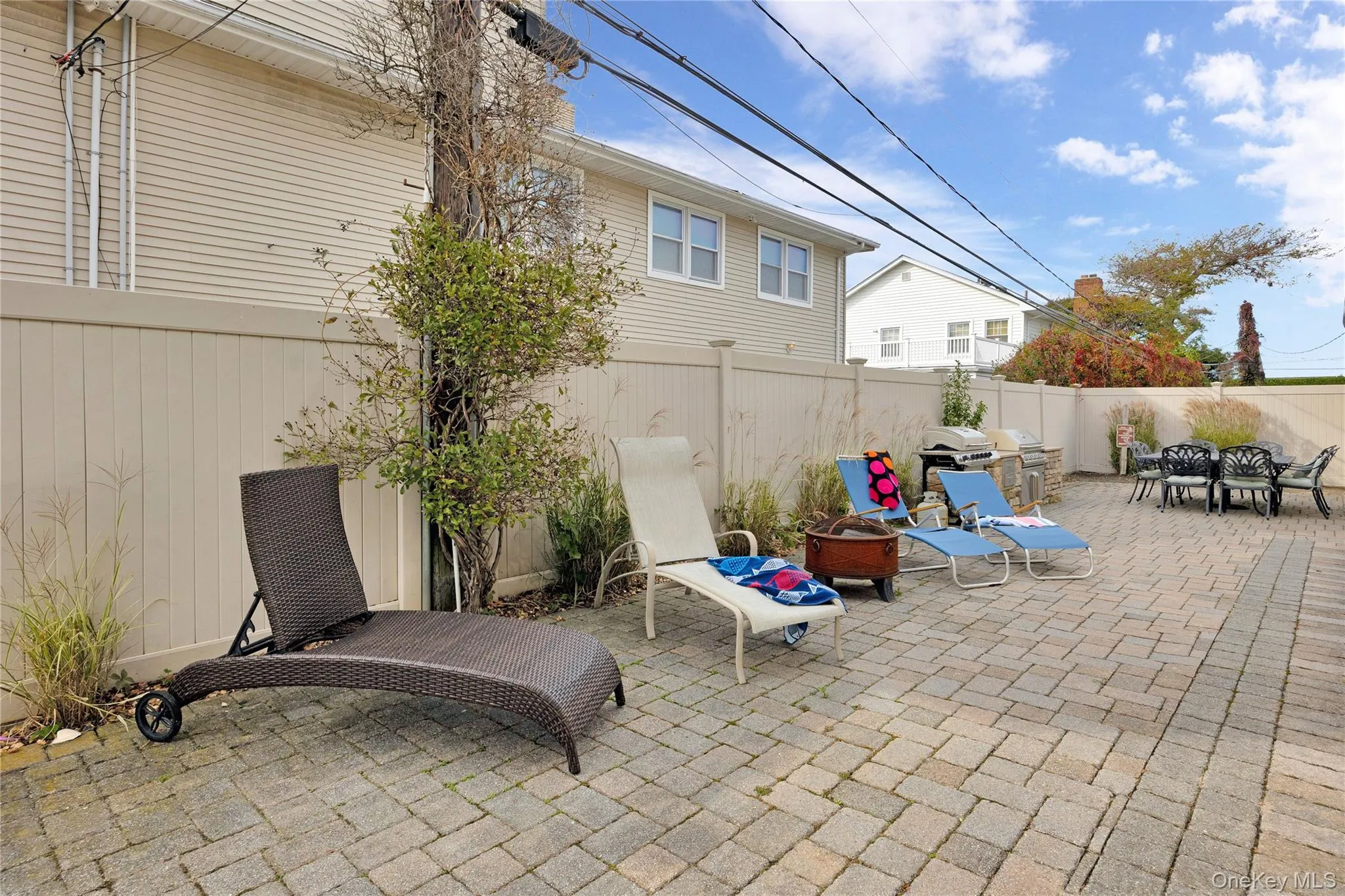 Fenced backyard featuring a patio area and a fire pit Fenced backyard featuring a patio area and a fire pit