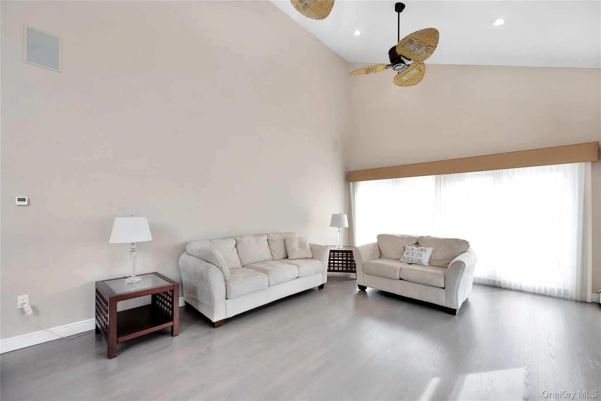 Living room with a high ceiling, wood finished floors, ceiling fan, and recessed lighting Living room with a high ceiling, wood finished floors, ceiling fan, and recessed lighting