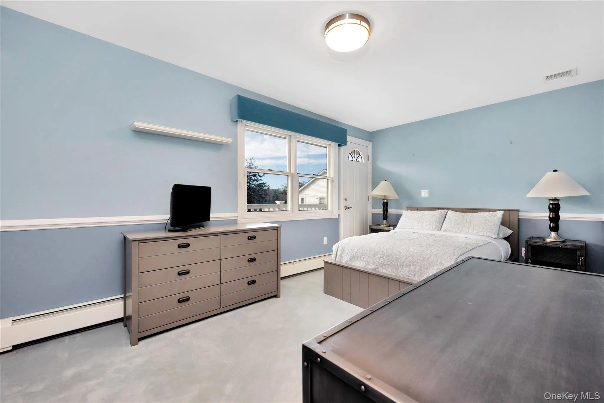Bedroom featuring a baseboard radiator and light colored carpet Bedroom featuring a baseboard radiator and light colored carpet