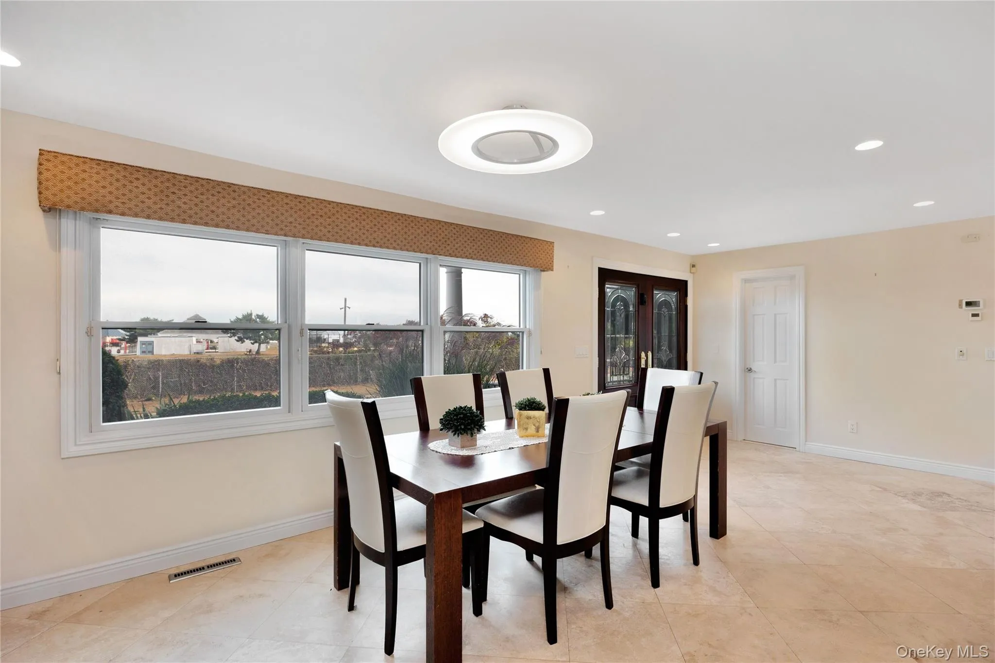 Dining room with recessed lighting and light tile patterned floors Dining room with recessed lighting and light tile patterned floors