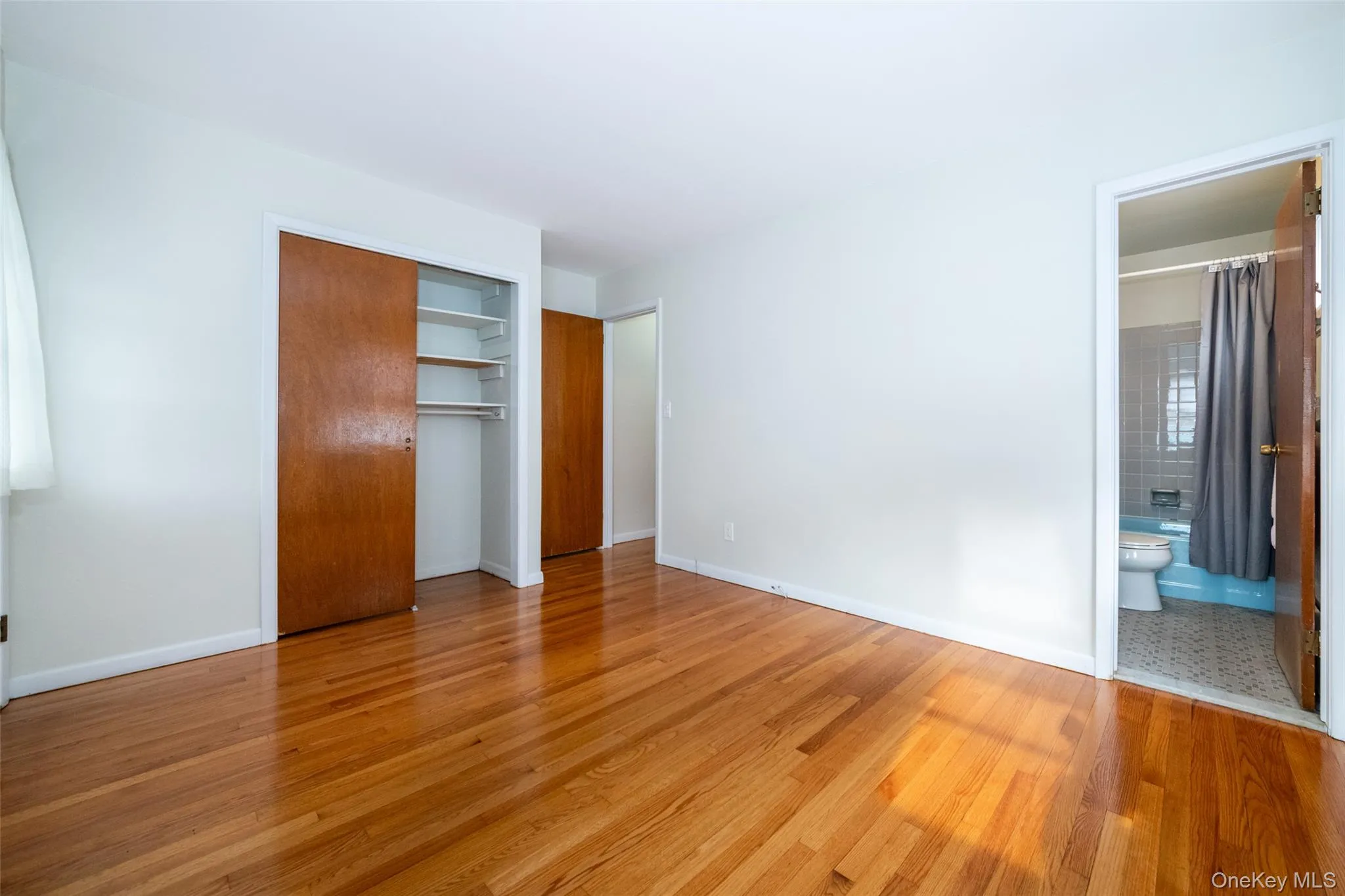 Unfurnished bedroom featuring light wood-type flooring, a closet, and ensuite bathroom Unfurnished bedroom featuring light wood-type flooring, a closet, and ensuite bathroom