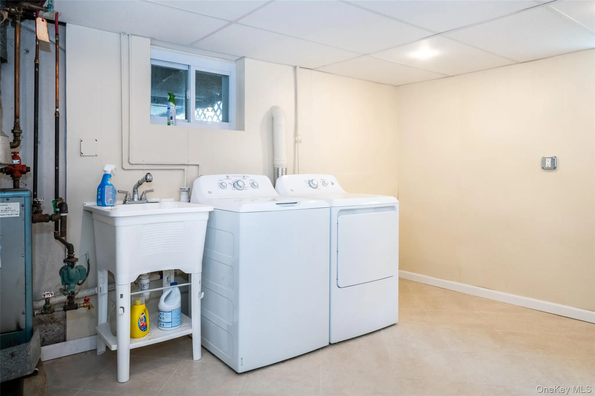 Laundry area with washer and clothes dryer, a paneled ceiling, and a heating unit Laundry area with washer and clothes dryer, a paneled ceiling, and a heating unit