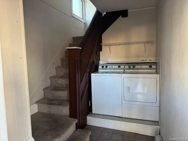 Washroom with independent washer and dryer and dark tile patterned flooring Washroom with independent washer and dryer and dark tile patterned flooring