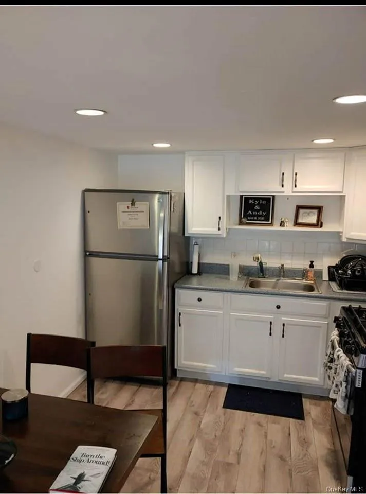 Kitchen with white cabinetry, decorative backsplash, stainless steel appliances, recessed lighting, and light wood-style flooring Kitchen with white cabinetry, decorative backsplash, stainless steel appliances, recessed lighting, and light wood-style flooring