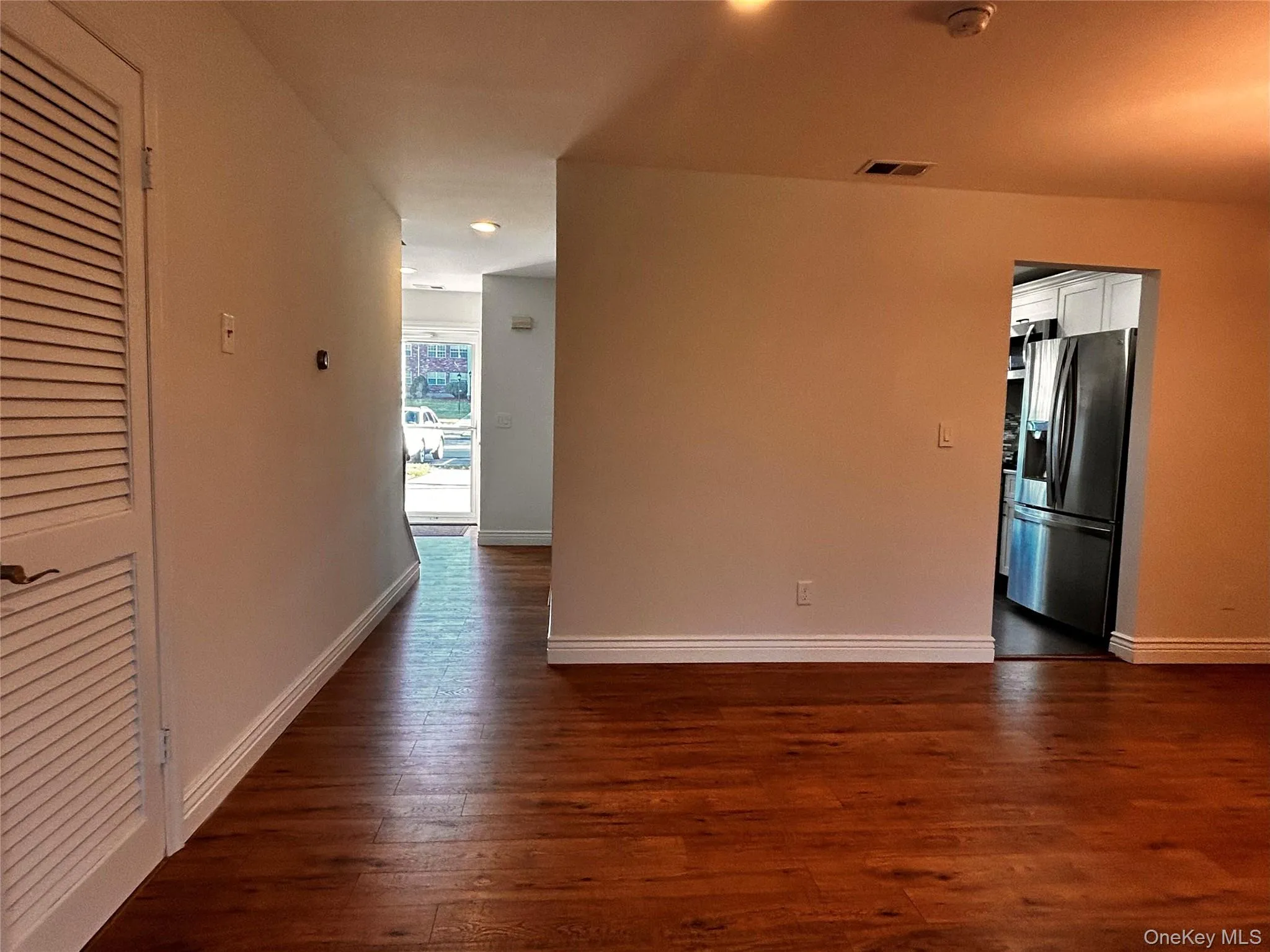 Empty room featuring dark wood-style flooring and a smoke detector Empty room featuring dark wood-style flooring and a smoke detector