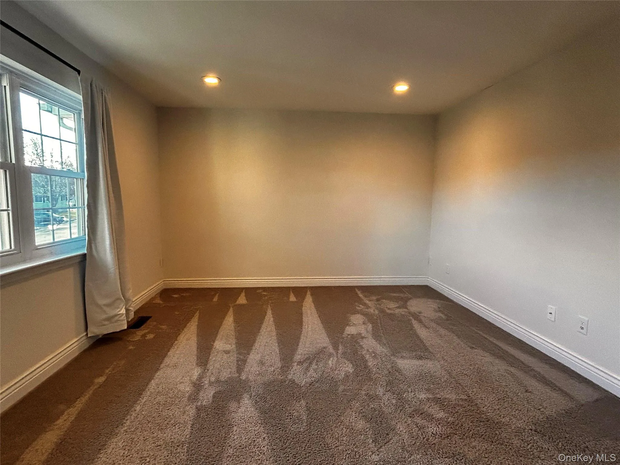 Unfurnished room featuring dark carpet and recessed lighting Unfurnished room featuring dark carpet and recessed lighting