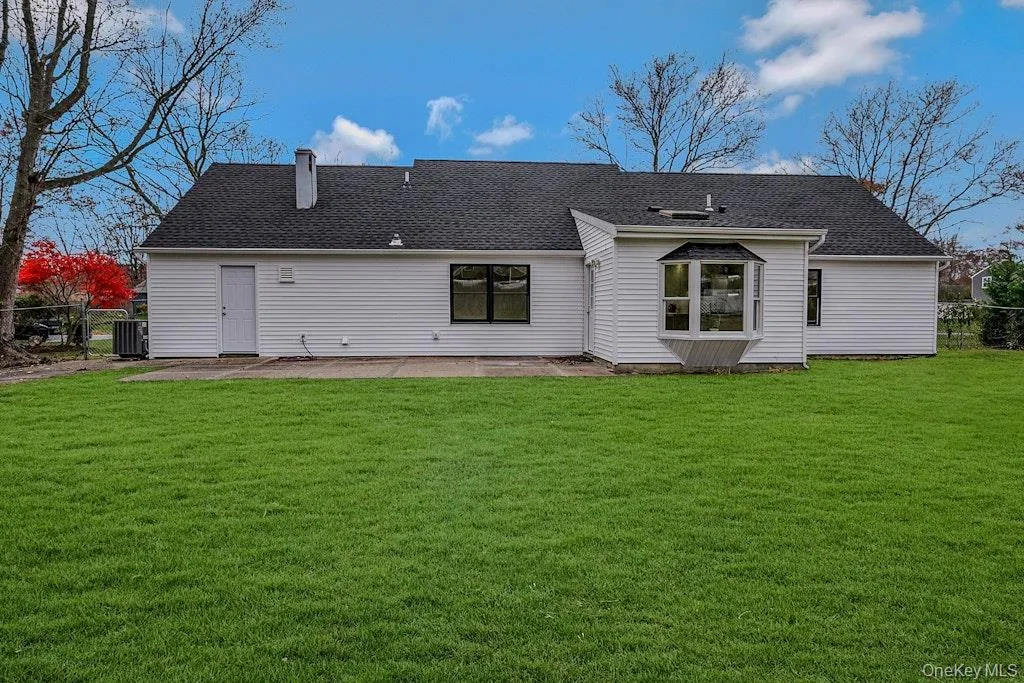 Back of house featuring a shingled roof, a patio area, and a chimney Back of house featuring a shingled roof, a patio area, and a chimney