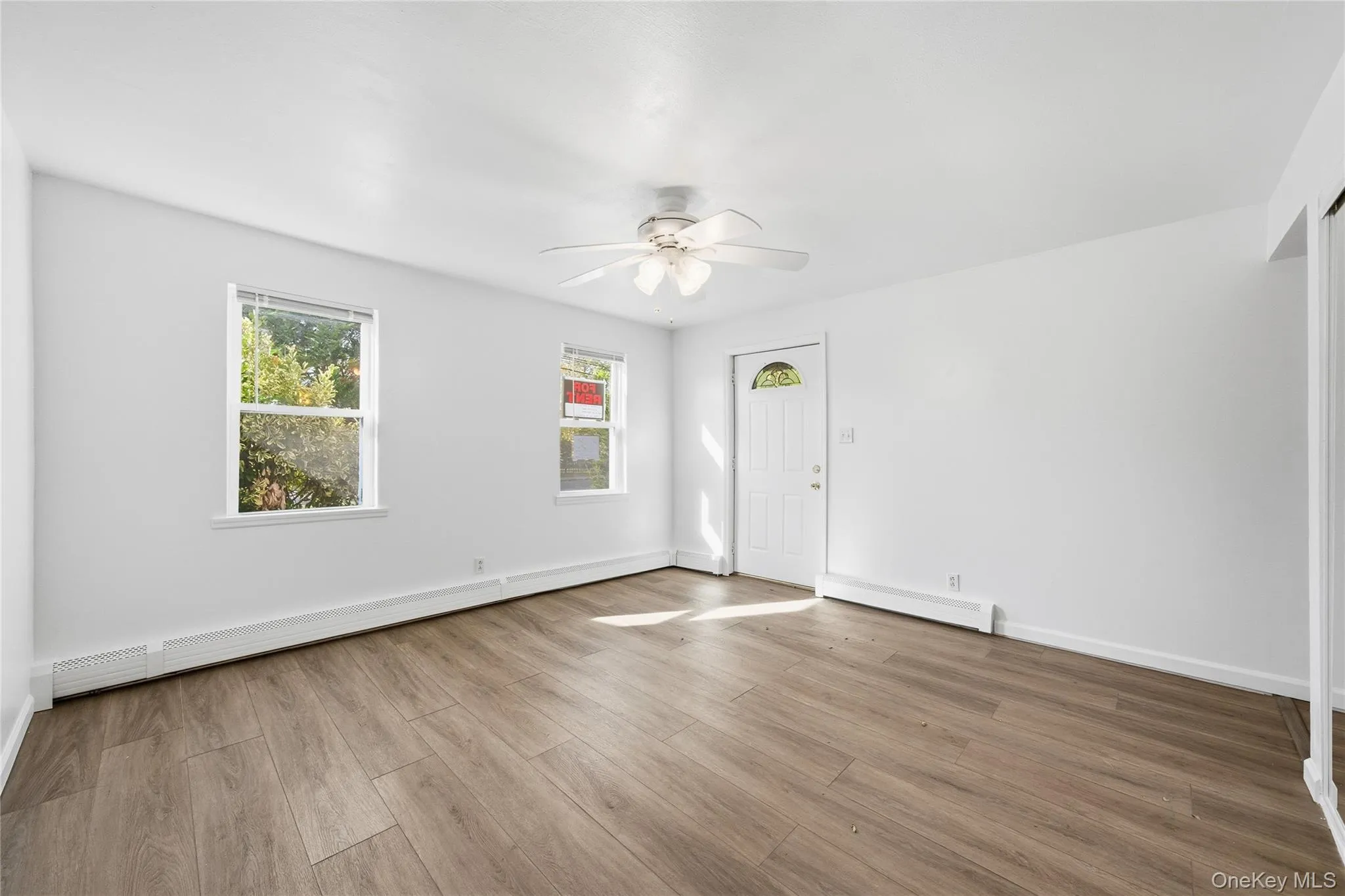 Spare room with a baseboard heating unit, light wood-style flooring, and a ceiling fan Spare room with a baseboard heating unit, light wood-style flooring, and a ceiling fan