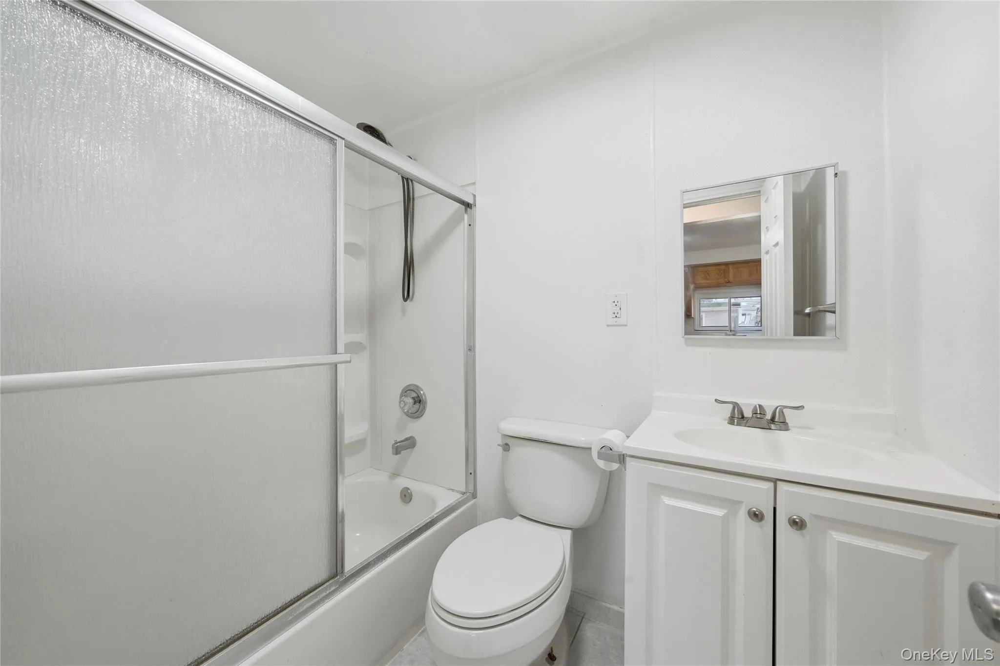 Bathroom featuring shower / bath combination with glass door and vanity Bathroom featuring shower / bath combination with glass door and vanity