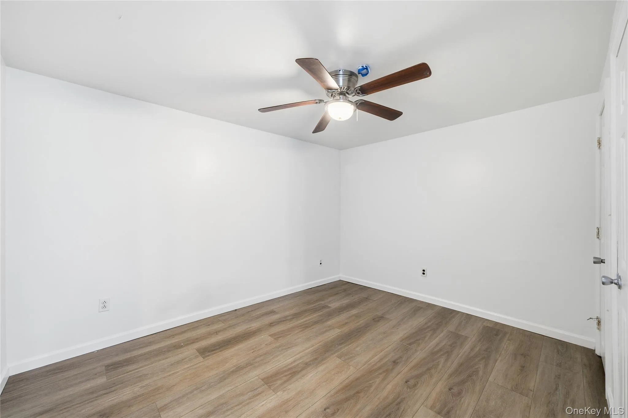 Unfurnished room with wood finished floors and a ceiling fan Unfurnished room with wood finished floors and a ceiling fan