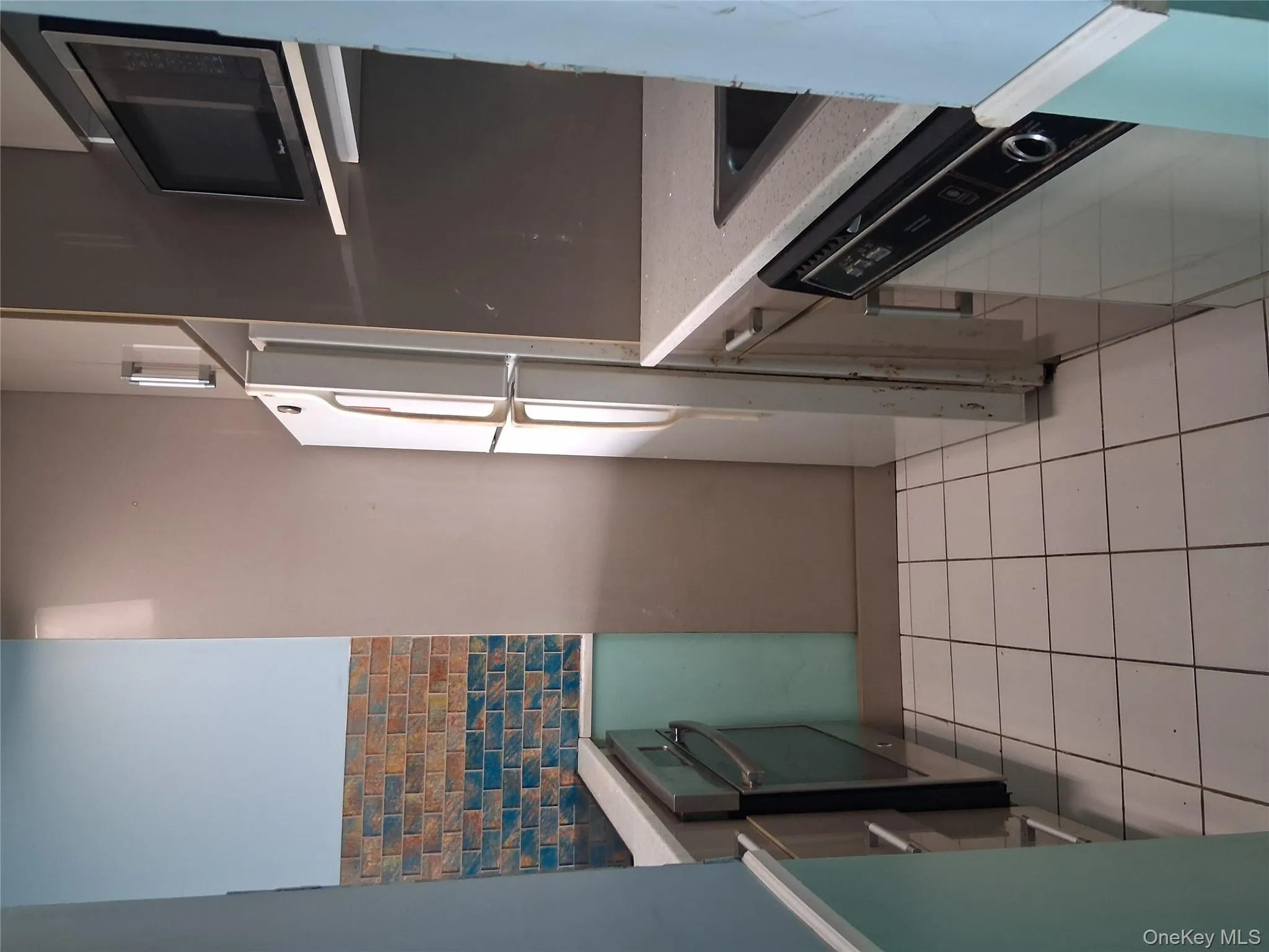 Kitchen featuring light tile patterned flooring, stainless steel fridge, fridge, wall oven, and dishwashing machine Kitchen featuring light tile patterned flooring, stainless steel fridge, fridge, wall oven, and dishwashing machine