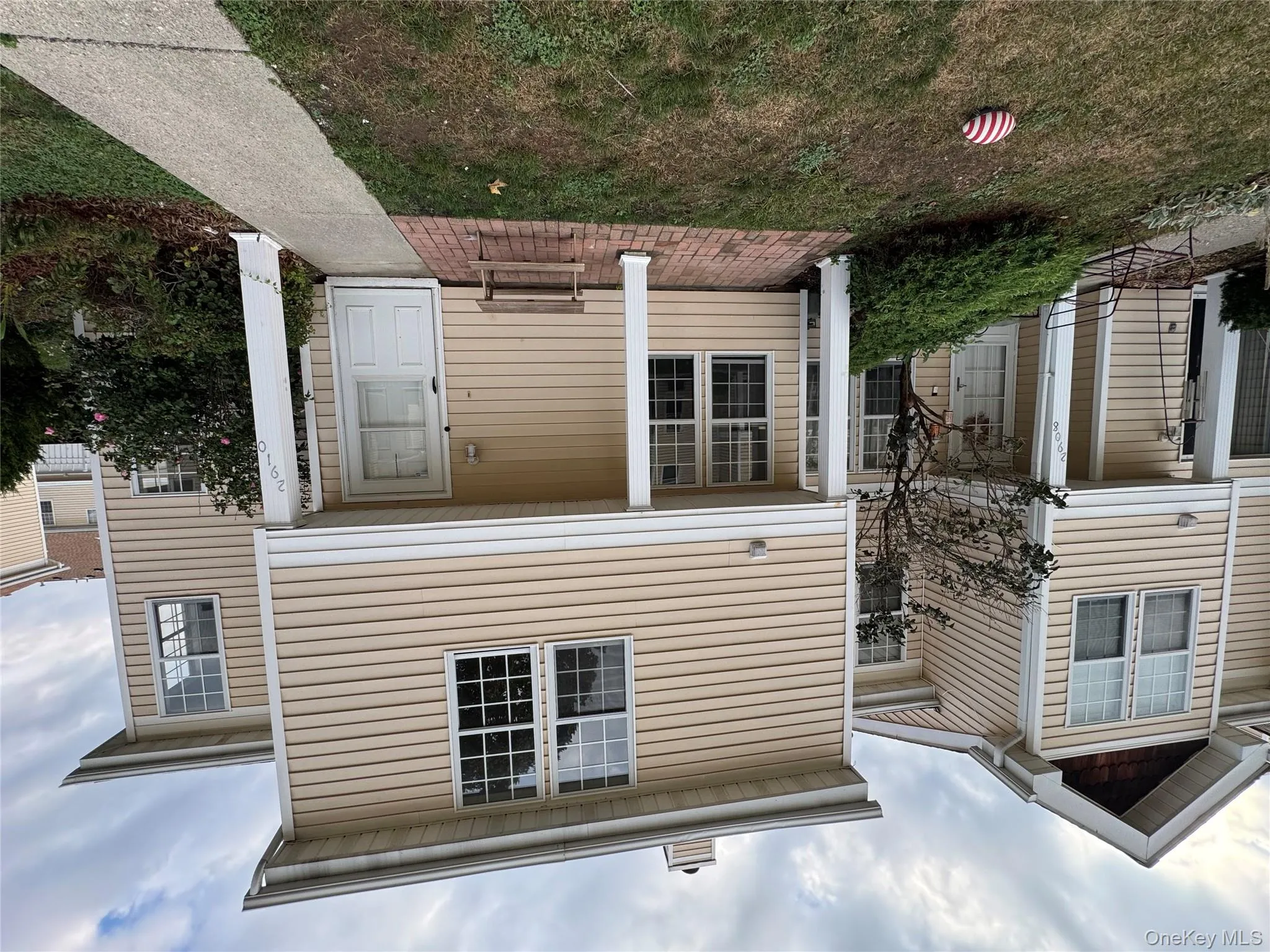 Traditional-style home featuring a chimney, a front yard, and a patio area Traditional-style home featuring a chimney, a front yard, and a patio area