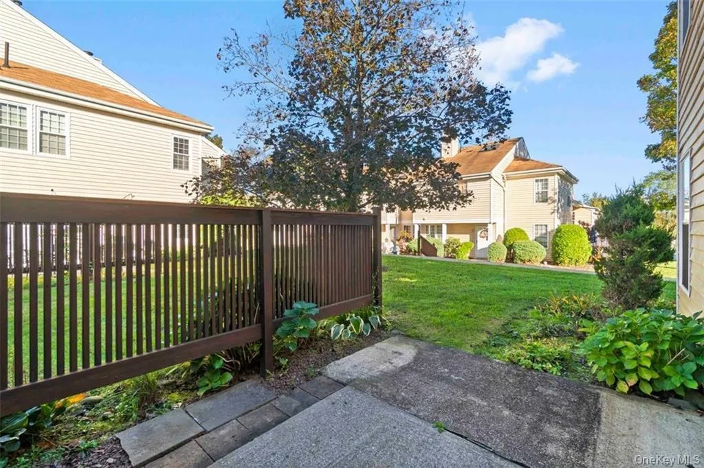 View of green lawn featuring a patio View of green lawn featuring a patio