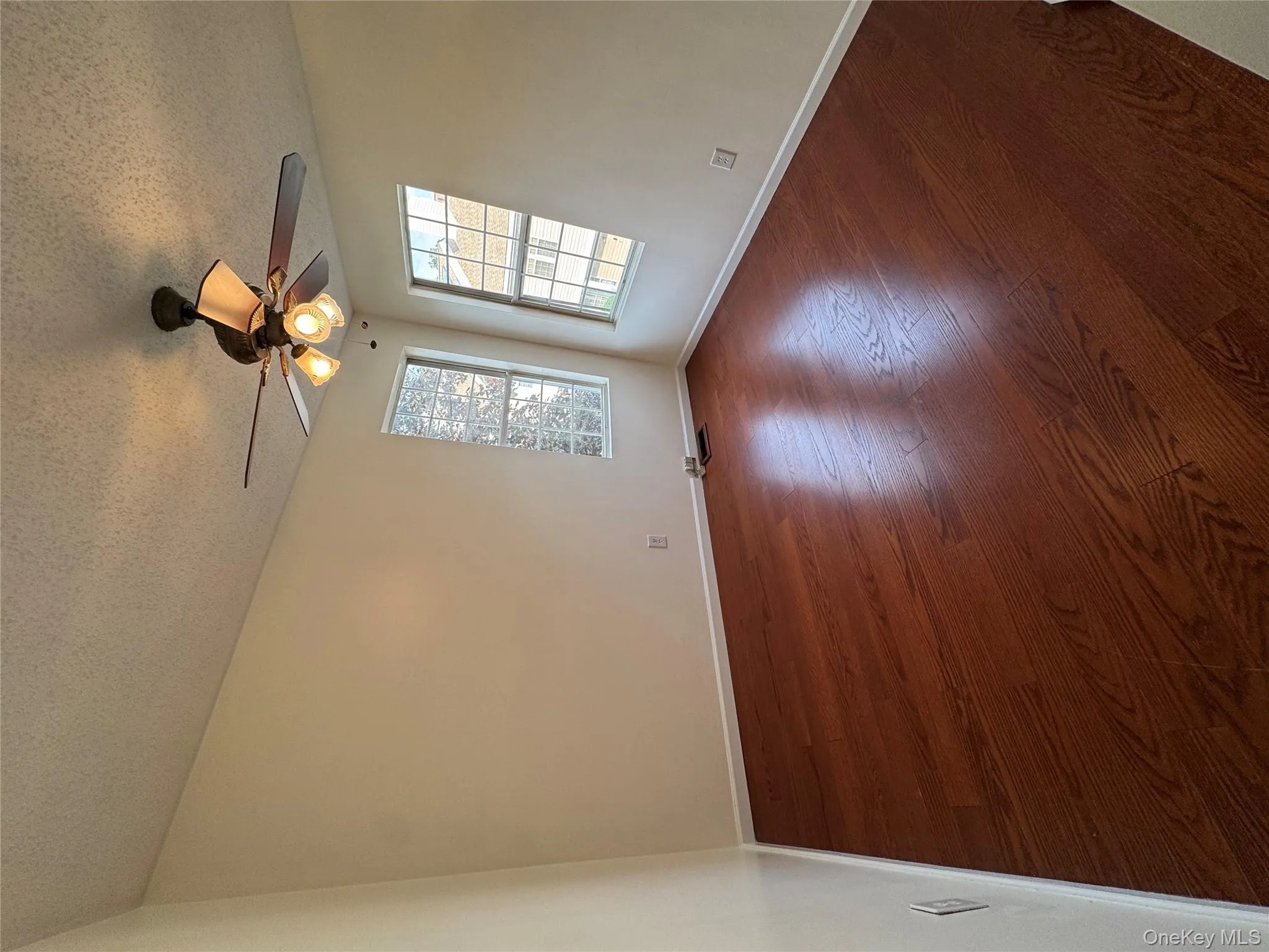 Empty room featuring dark wood-style flooring and a textured ceiling Empty room featuring dark wood-style flooring and a textured ceiling