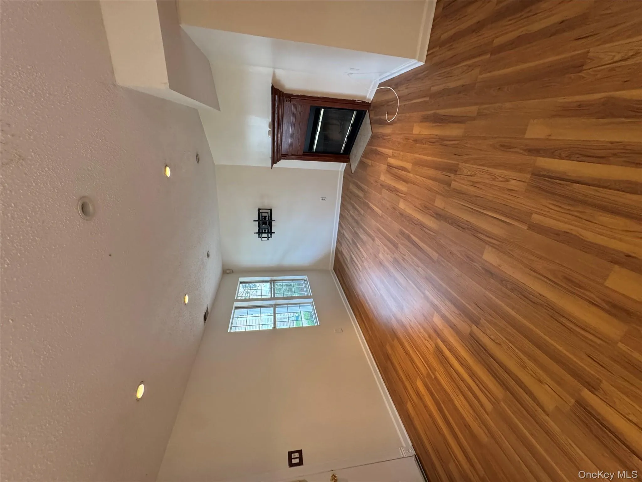 Unfurnished living room featuring a textured ceiling, a fireplace with flush hearth, light wood-style floors, and recessed lighting Unfurnished living room featuring a textured ceiling, a fireplace with flush hearth, light wood-style floors, and recessed lighting