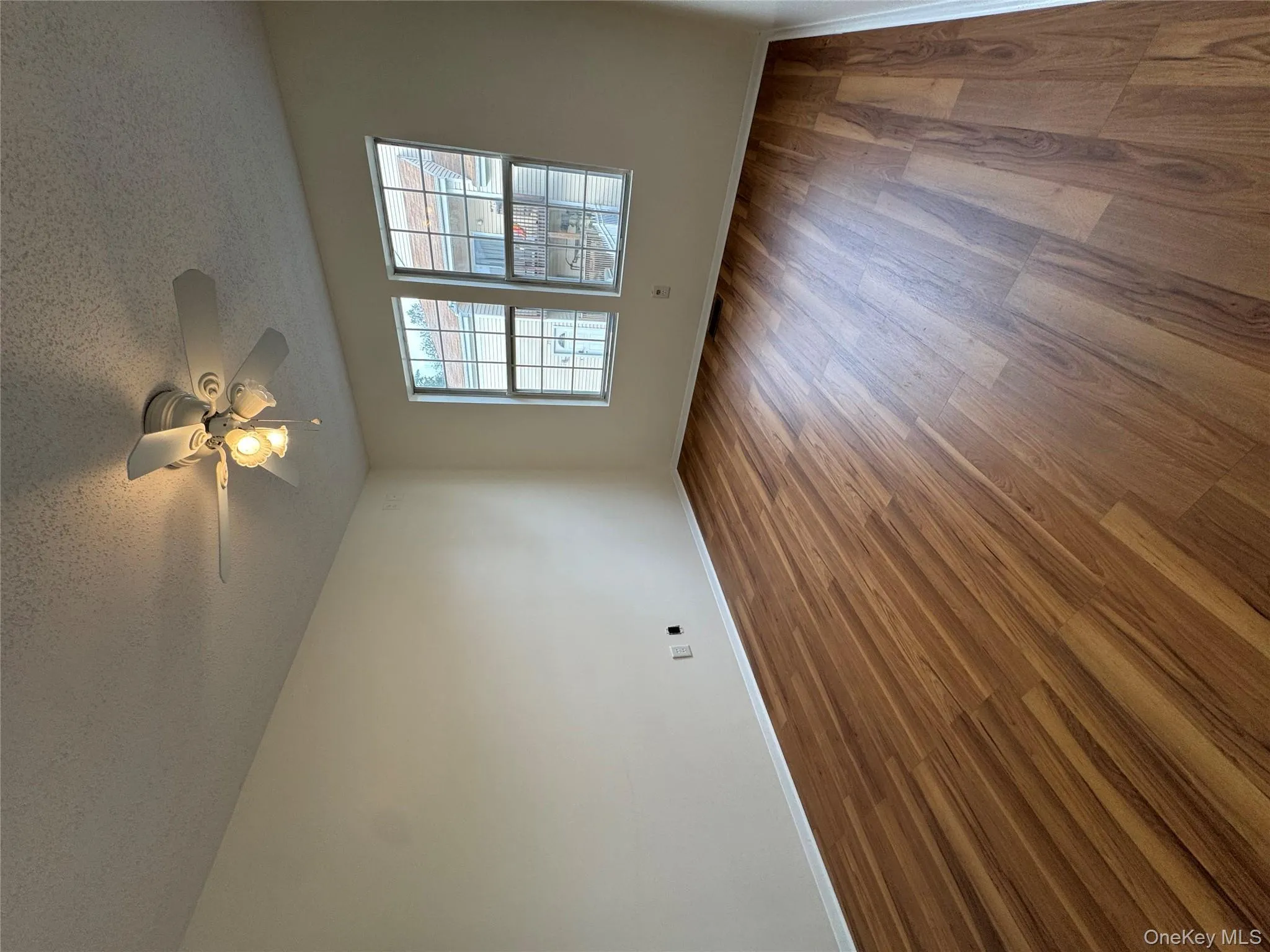 Unfurnished room with wood finished floors and a textured ceiling Unfurnished room with wood finished floors and a textured ceiling