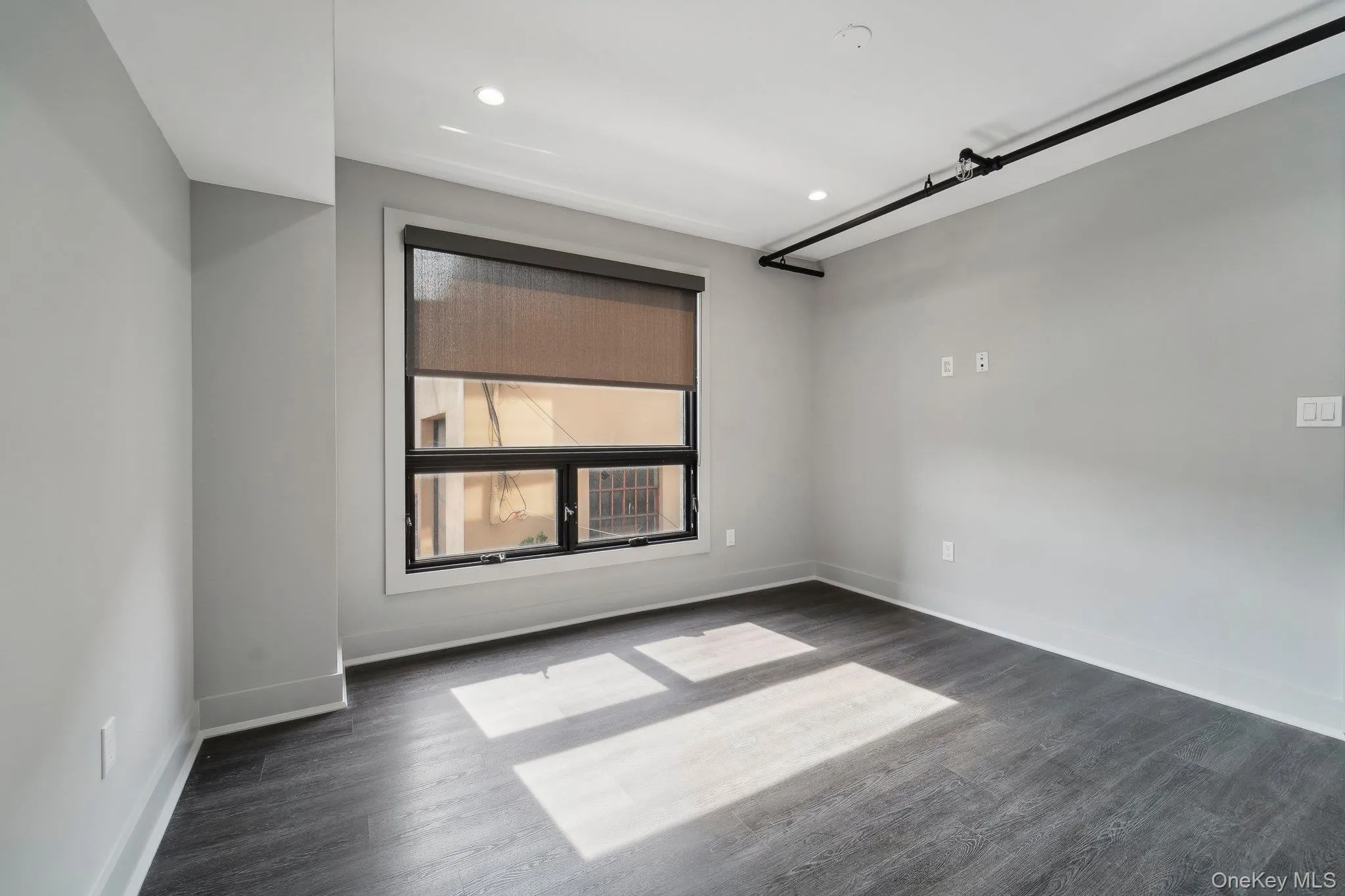 Unfurnished room with dark wood-style flooring and recessed lighting Unfurnished room with dark wood-style flooring and recessed lighting