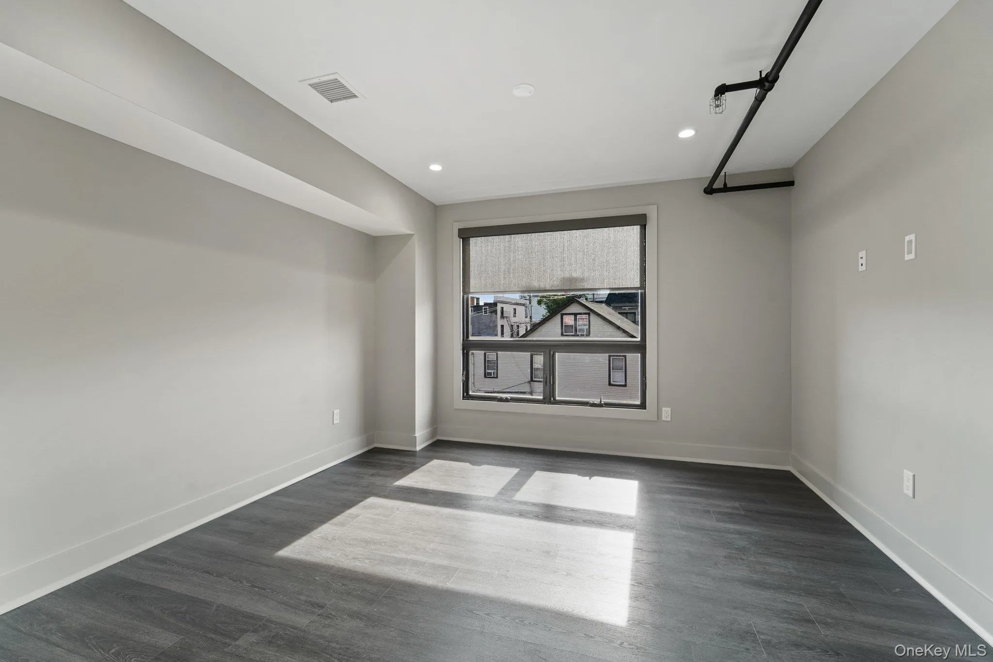 Empty room with dark wood-type flooring and recessed lighting Empty room with dark wood-type flooring and recessed lighting