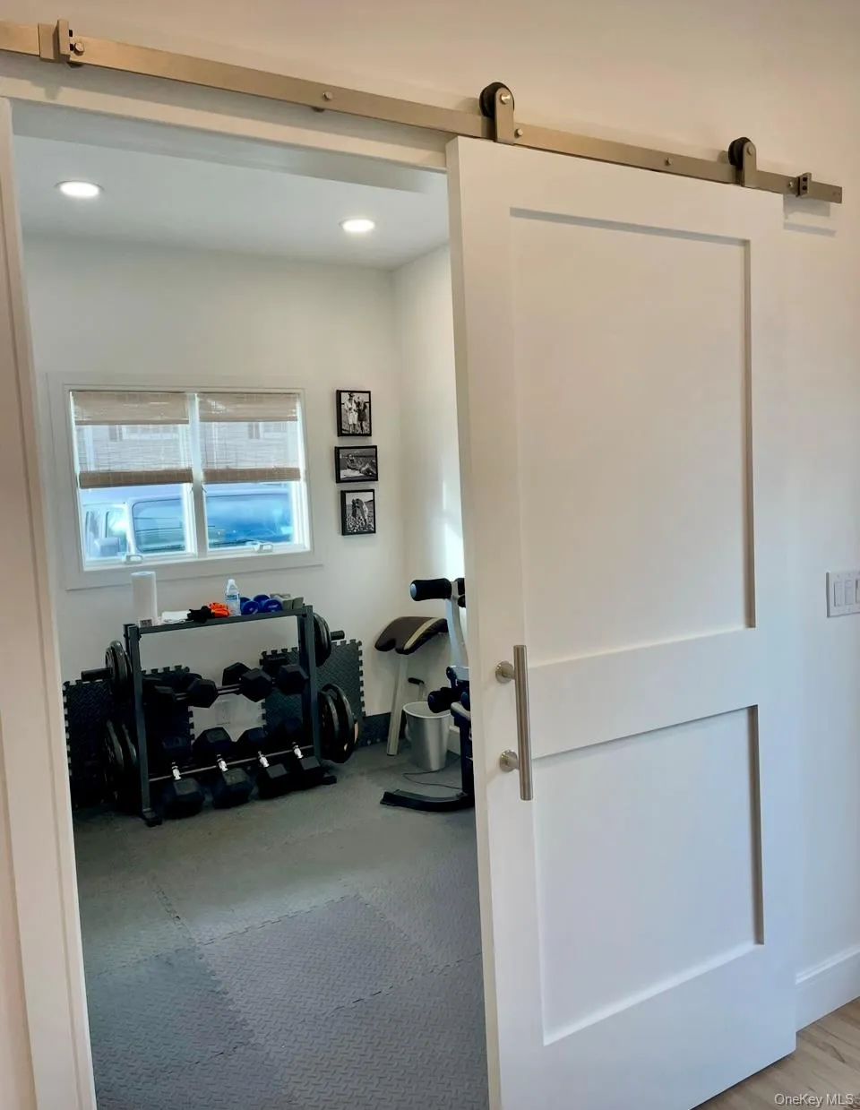 Exercise room with a barn door and recessed lighting Exercise room with a barn door and recessed lighting