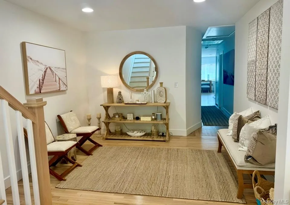 Living area featuring light wood finished floors, recessed lighting, and stairs Living area featuring light wood finished floors, recessed lighting, and stairs