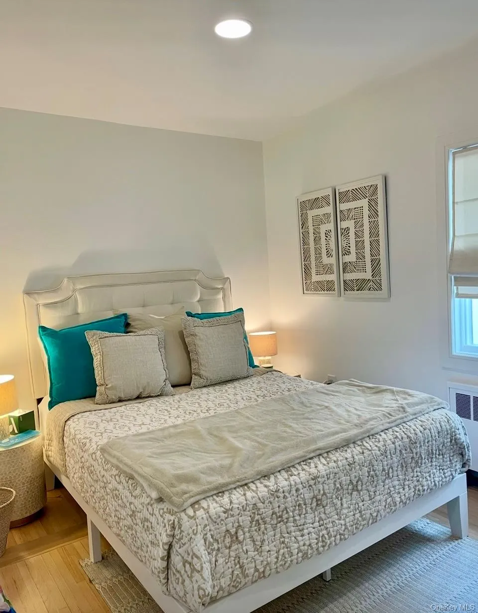 Bedroom with wood finished floors, recessed lighting, and radiator Bedroom with wood finished floors, recessed lighting, and radiator