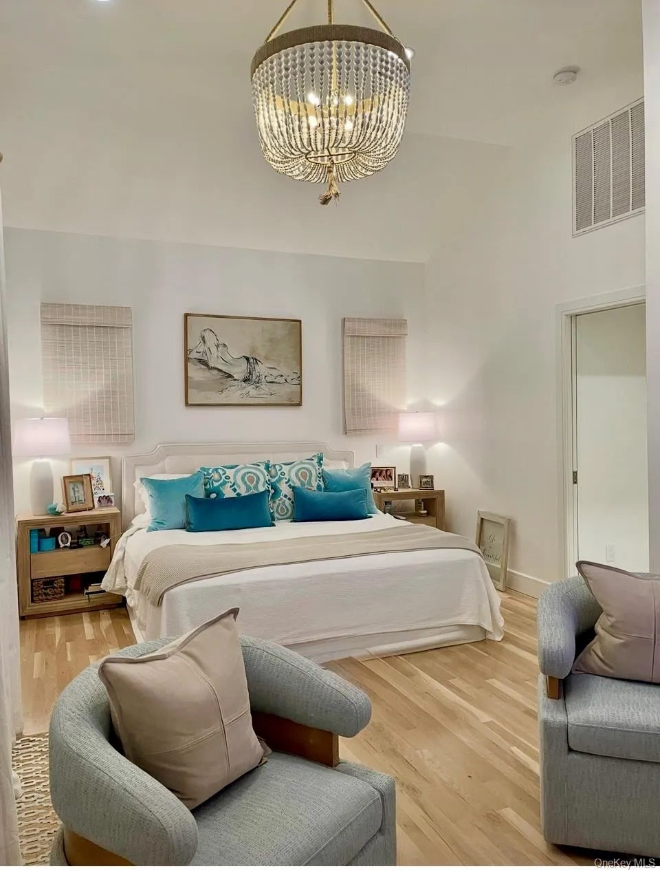 Bedroom with wood finished floors, a chandelier, and a towering ceiling Bedroom with wood finished floors, a chandelier, and a towering ceiling