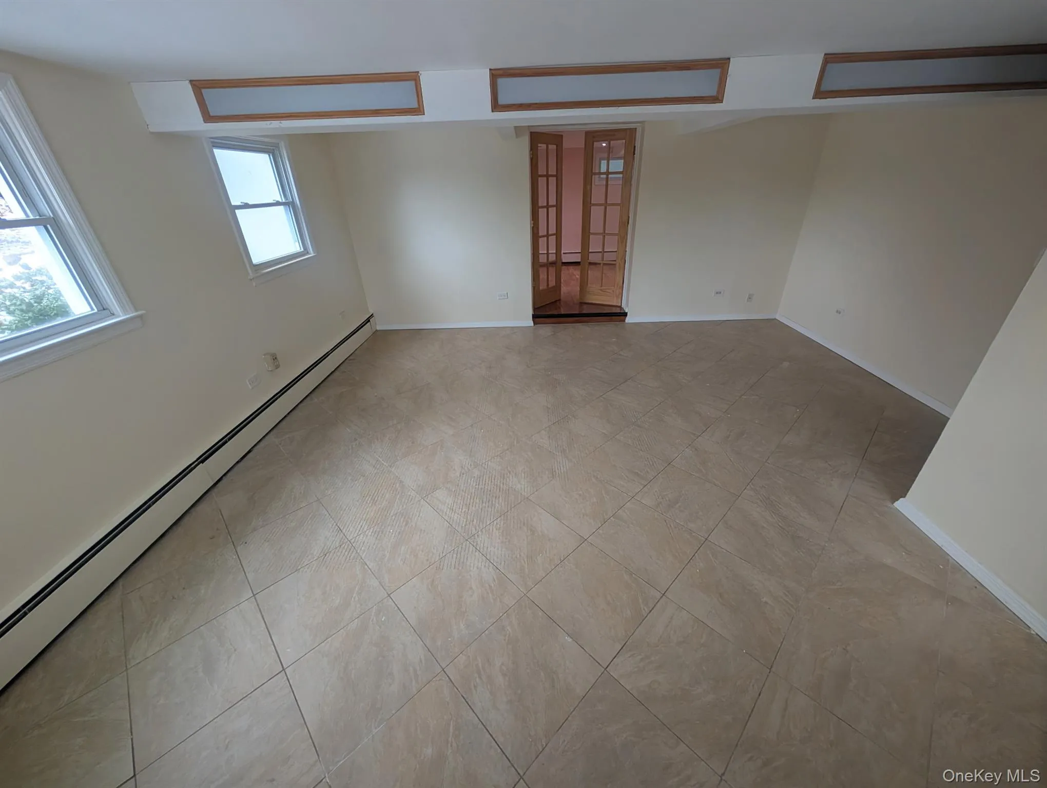 Unfurnished room with a baseboard heating unit and baseboards Unfurnished room with a baseboard heating unit and baseboards