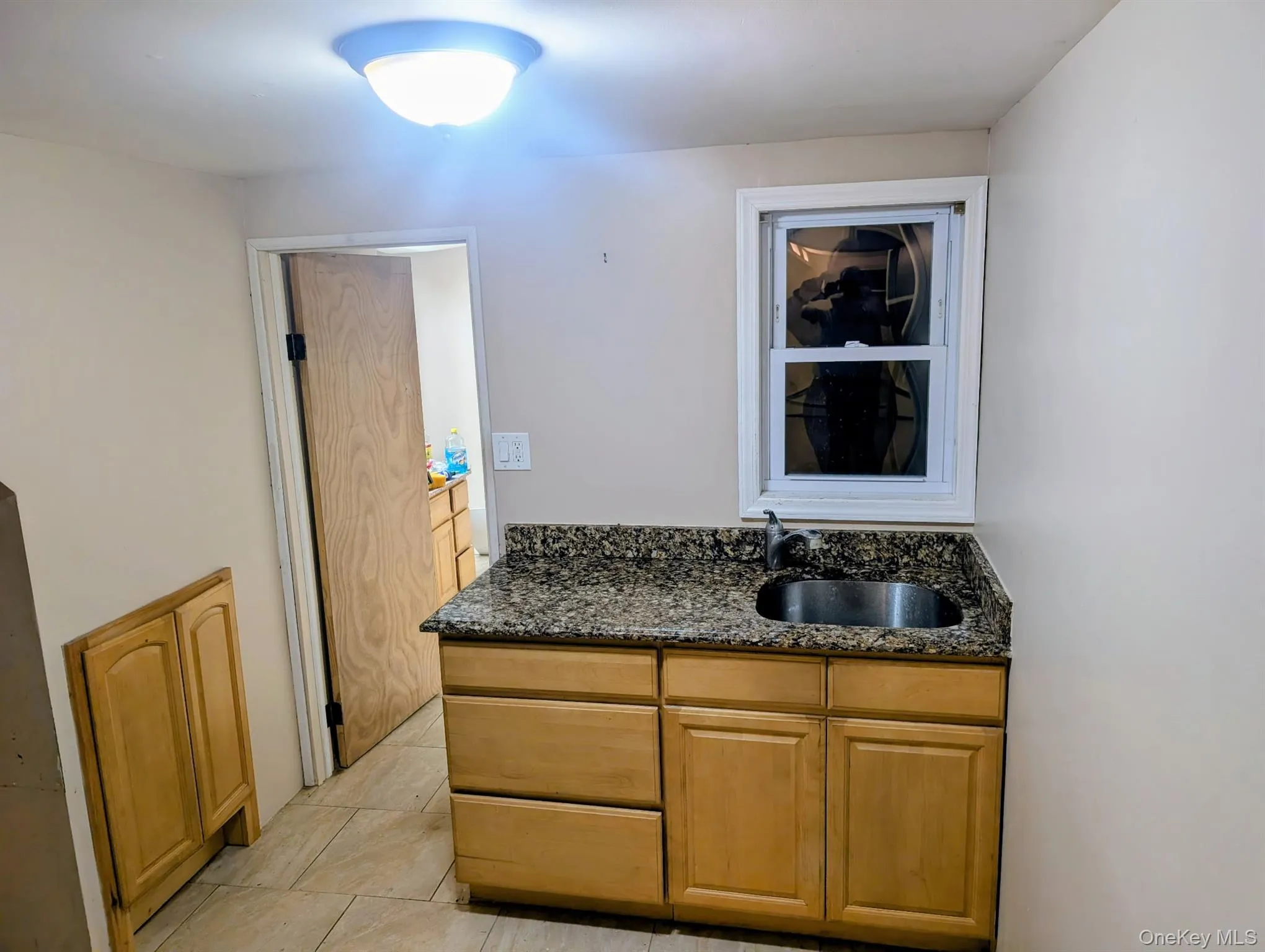 Kitchen with dark stone countertops and light tile patterned flooring Kitchen with dark stone countertops and light tile patterned flooring