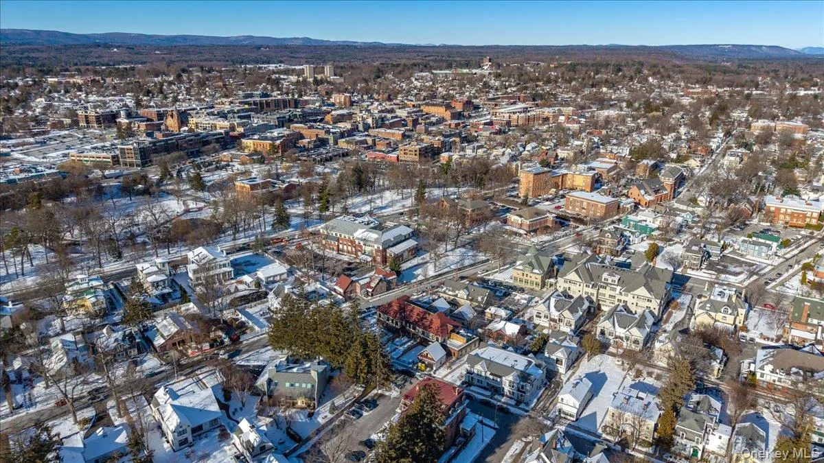 Aerial view of property and surrounding area with mountains and nearby urban area Aerial view of property and surrounding area with mountains and nearby urban area