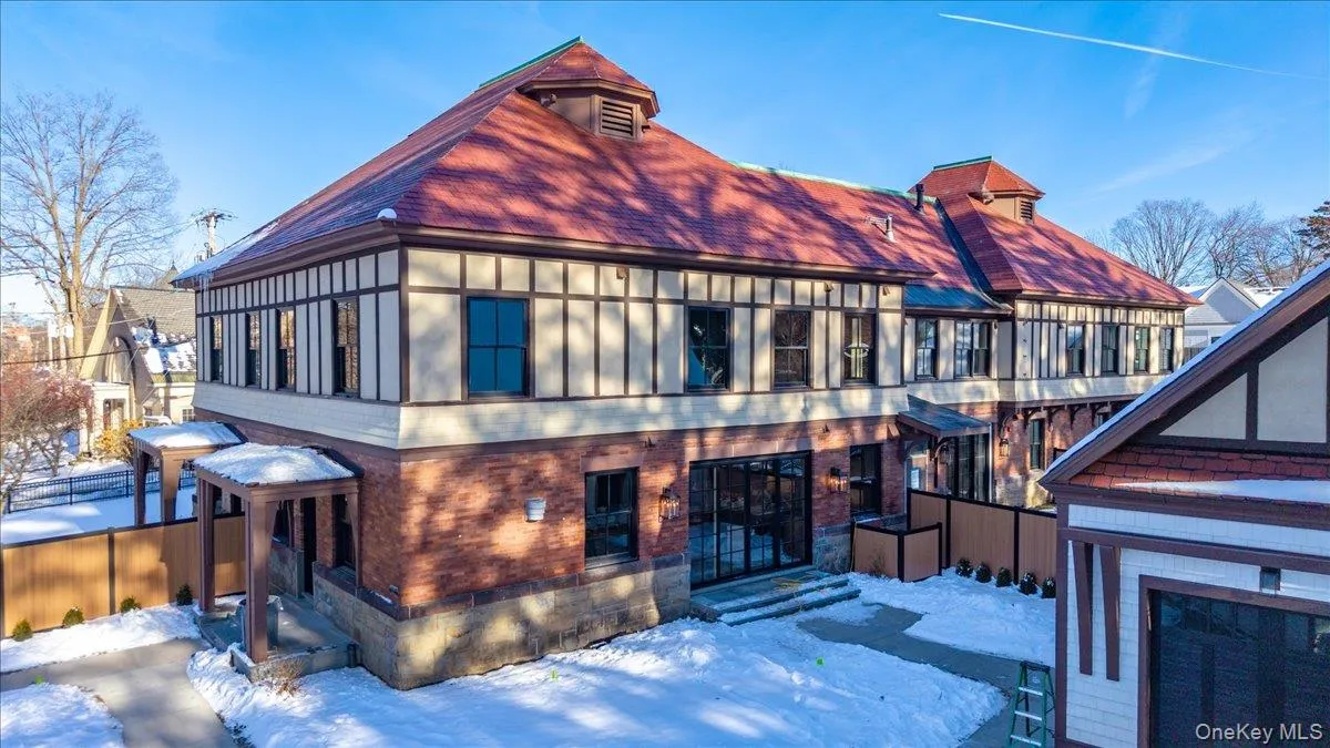 Snow covered property featuring brick siding and a shingled roof Snow covered property featuring brick siding and a shingled roof