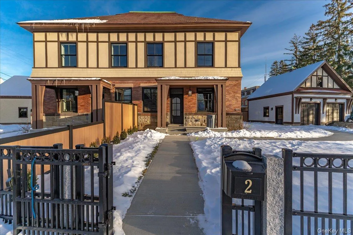 View of front of property with a fenced front yard, a gate, brick siding, and stone siding View of front of property with a fenced front yard, a gate, brick siding, and stone siding