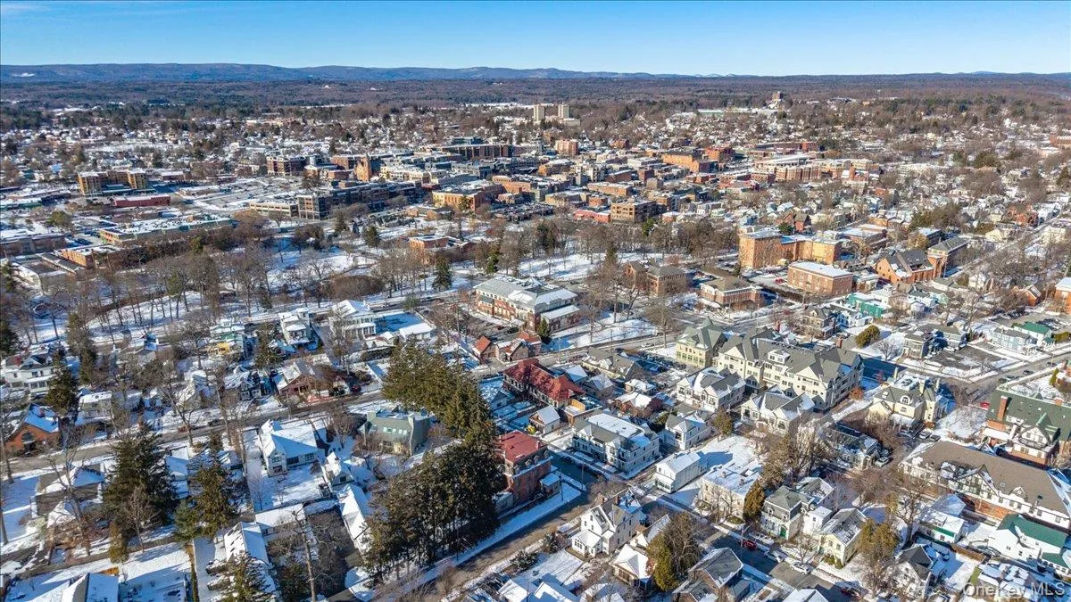 Aerial view of property and surrounding area with nearby urban area and a mountain backdrop Aerial view of property and surrounding area with nearby urban area and a mountain backdrop