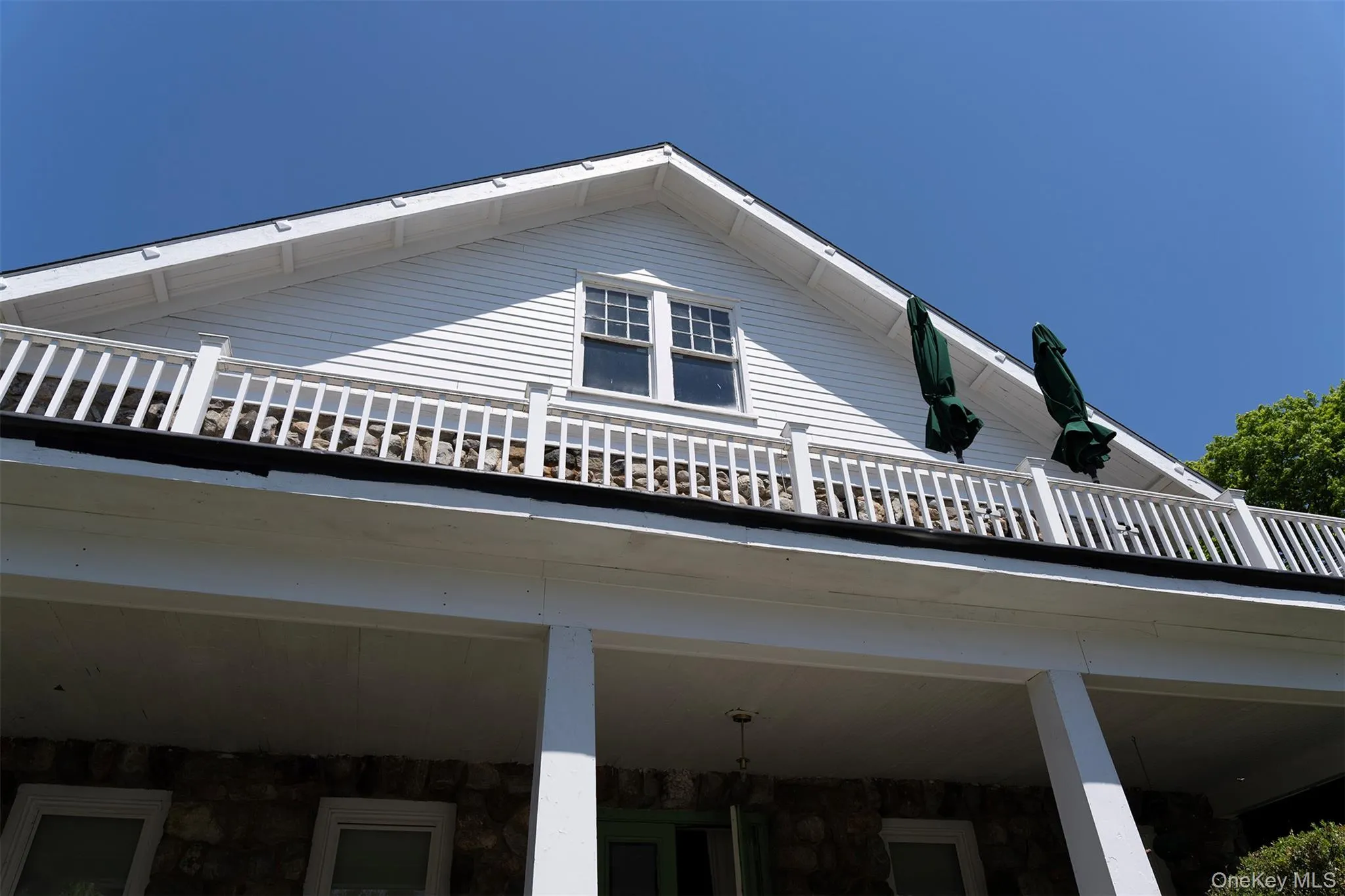 View of property exterior featuring a balcony and stone siding View of property exterior featuring a balcony and stone siding
