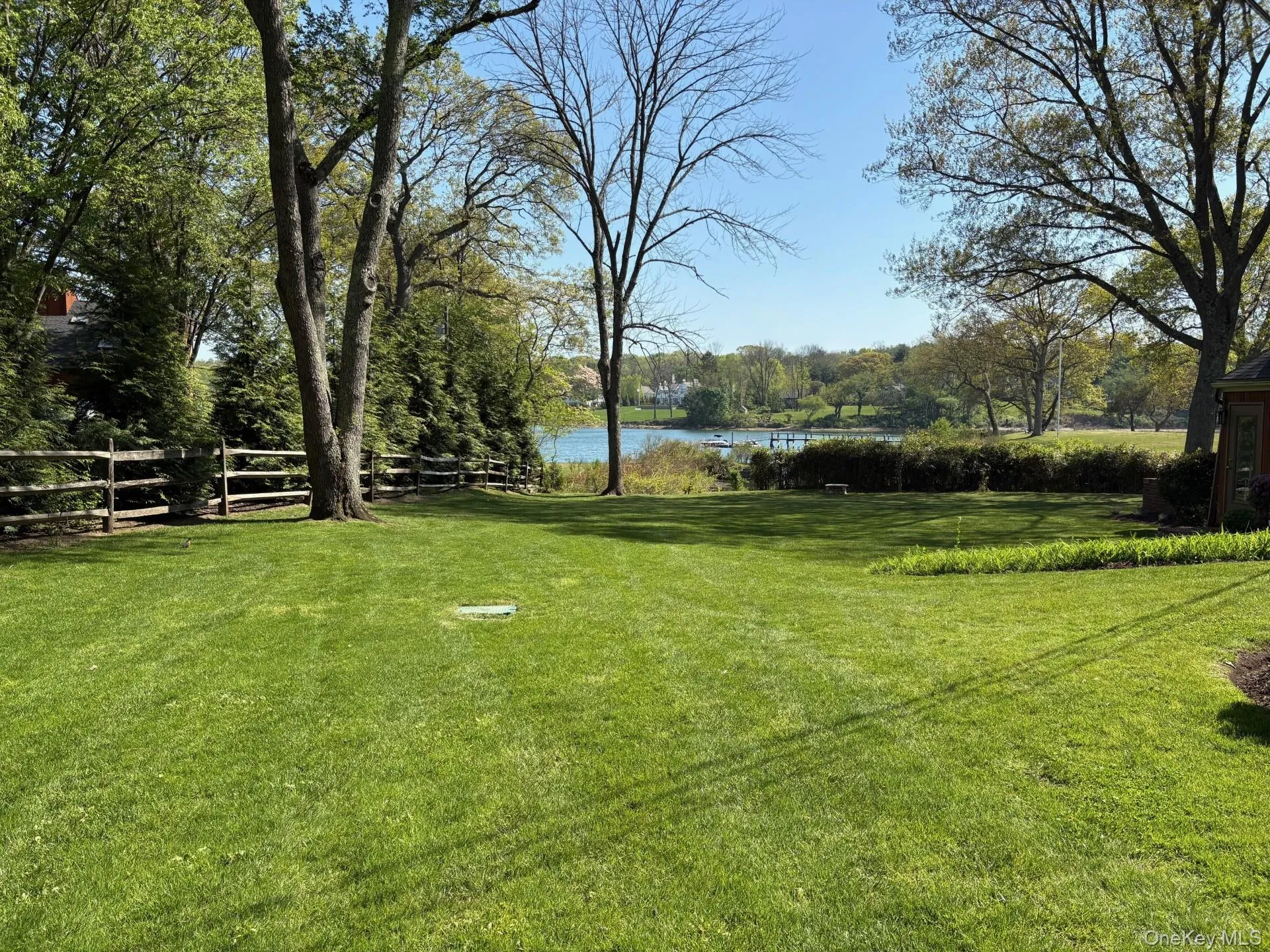 Expansive lawn featuring mature trees and a split rail fence Expansive lawn featuring mature trees and a split rail fence