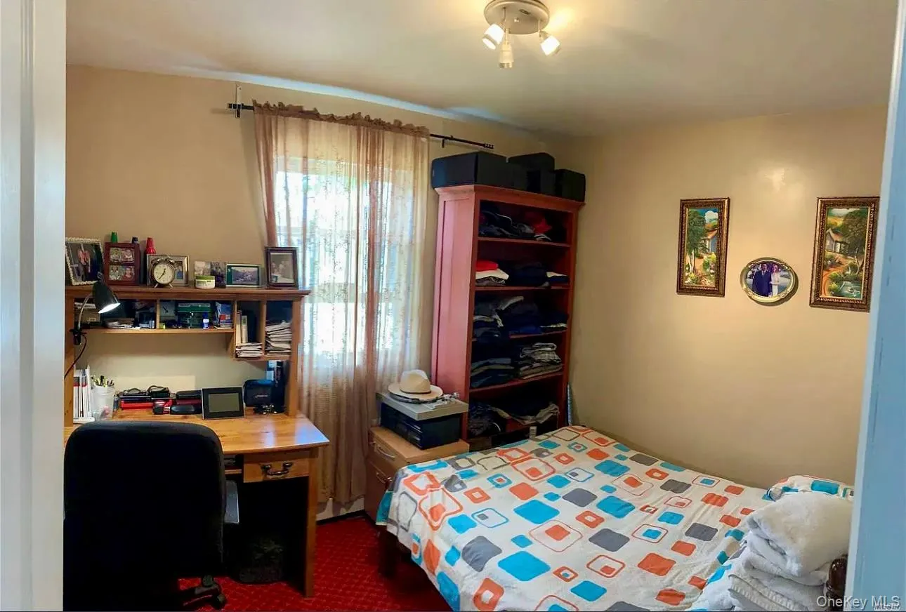 Bedroom with dark carpet and a desk Bedroom with dark carpet and a desk