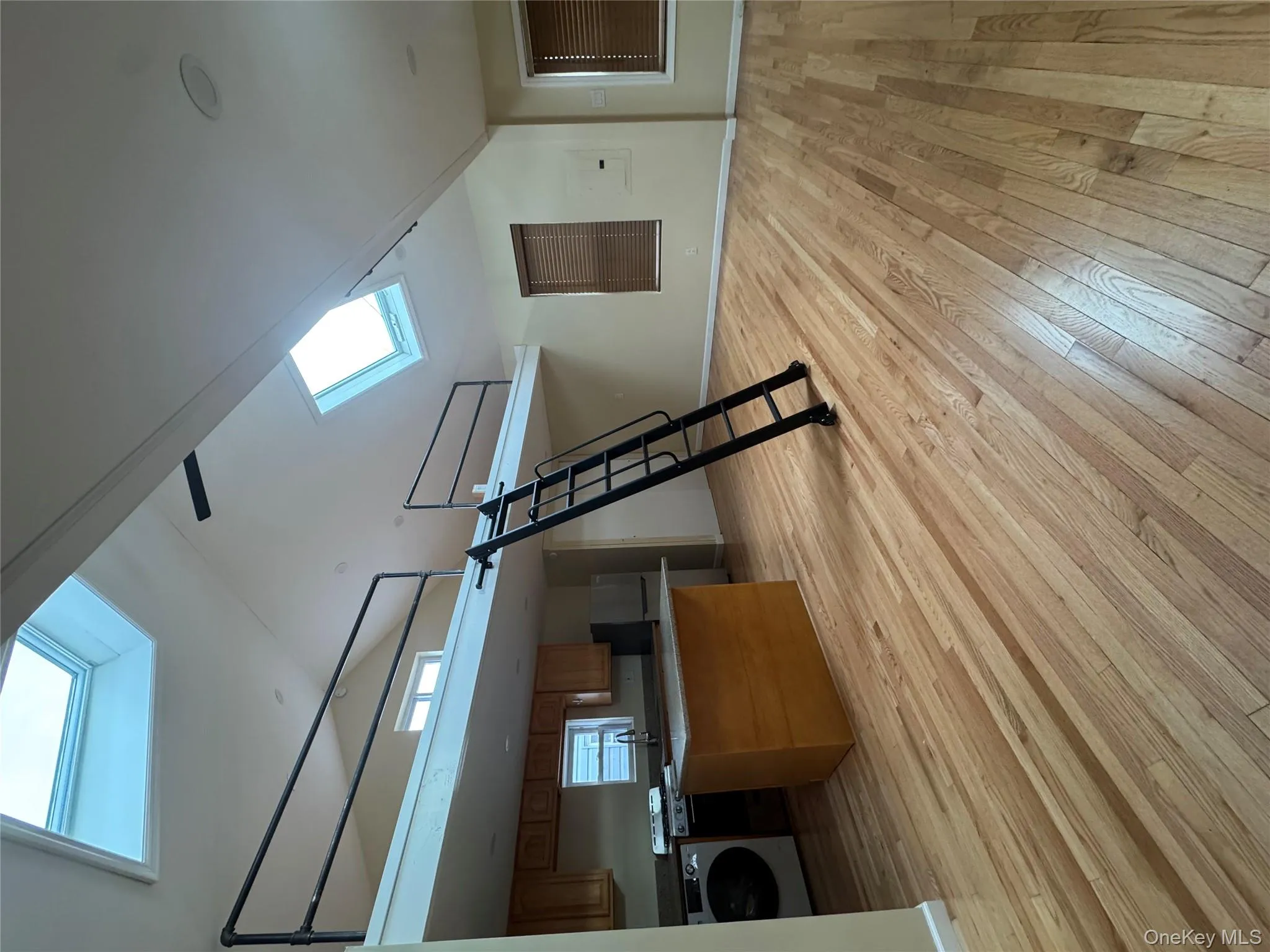 Additional living space featuring a skylight, washer / dryer, light wood finished floors, and high vaulted ceiling Additional living space featuring a skylight, washer / dryer, light wood finished floors, and high vaulted ceiling