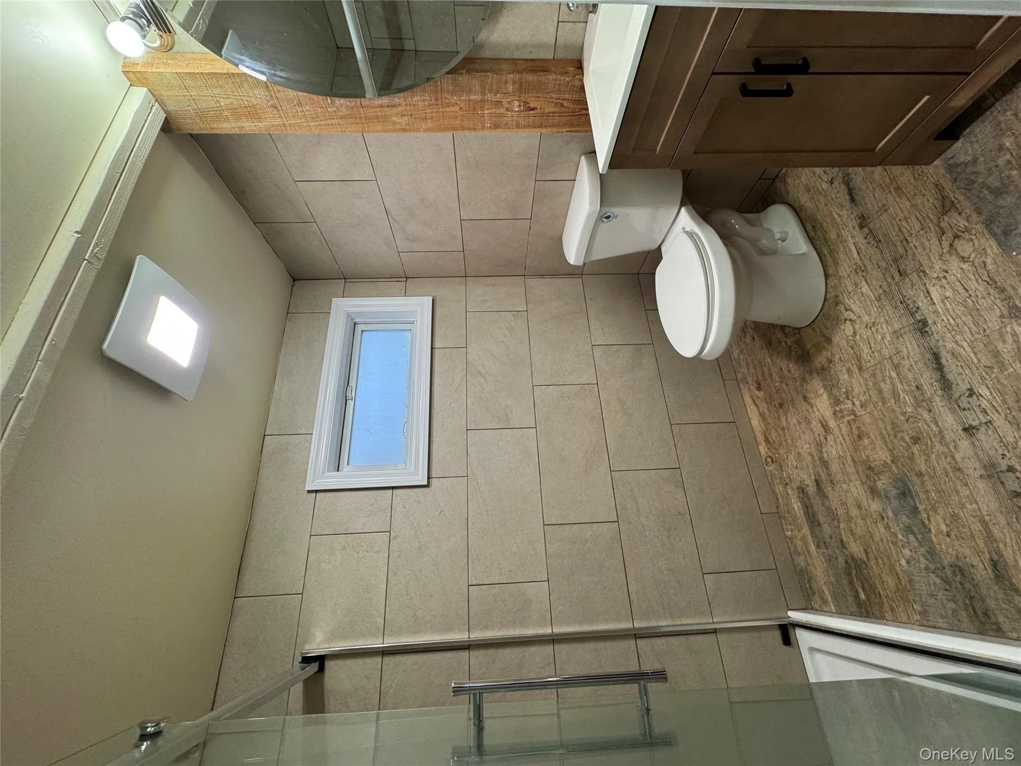 Full bath featuring a stall shower, vanity, tile walls, and dark wood-style floors Full bath featuring a stall shower, vanity, tile walls, and dark wood-style floors