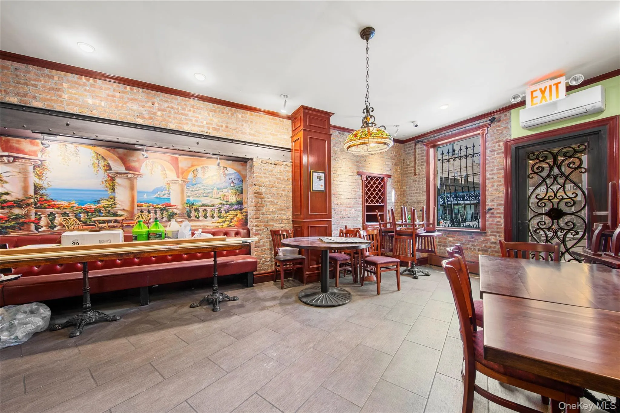 Dining space featuring brick wall, ornamental molding, and an AC wall unit Dining space featuring brick wall, ornamental molding, and an AC wall unit