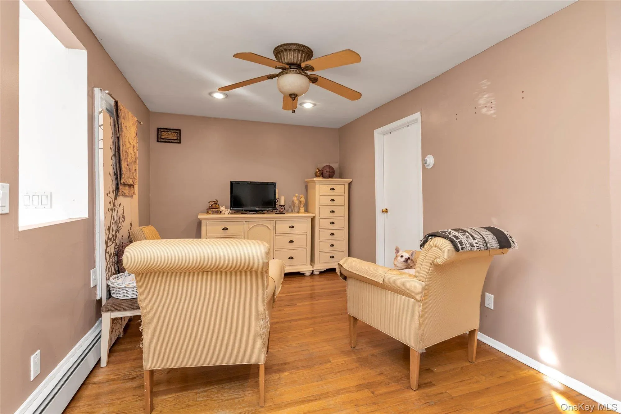 Living room with baseboard heating, light wood-type flooring, ceiling fan, and recessed lighting Living room with baseboard heating, light wood-type flooring, ceiling fan, and recessed lighting