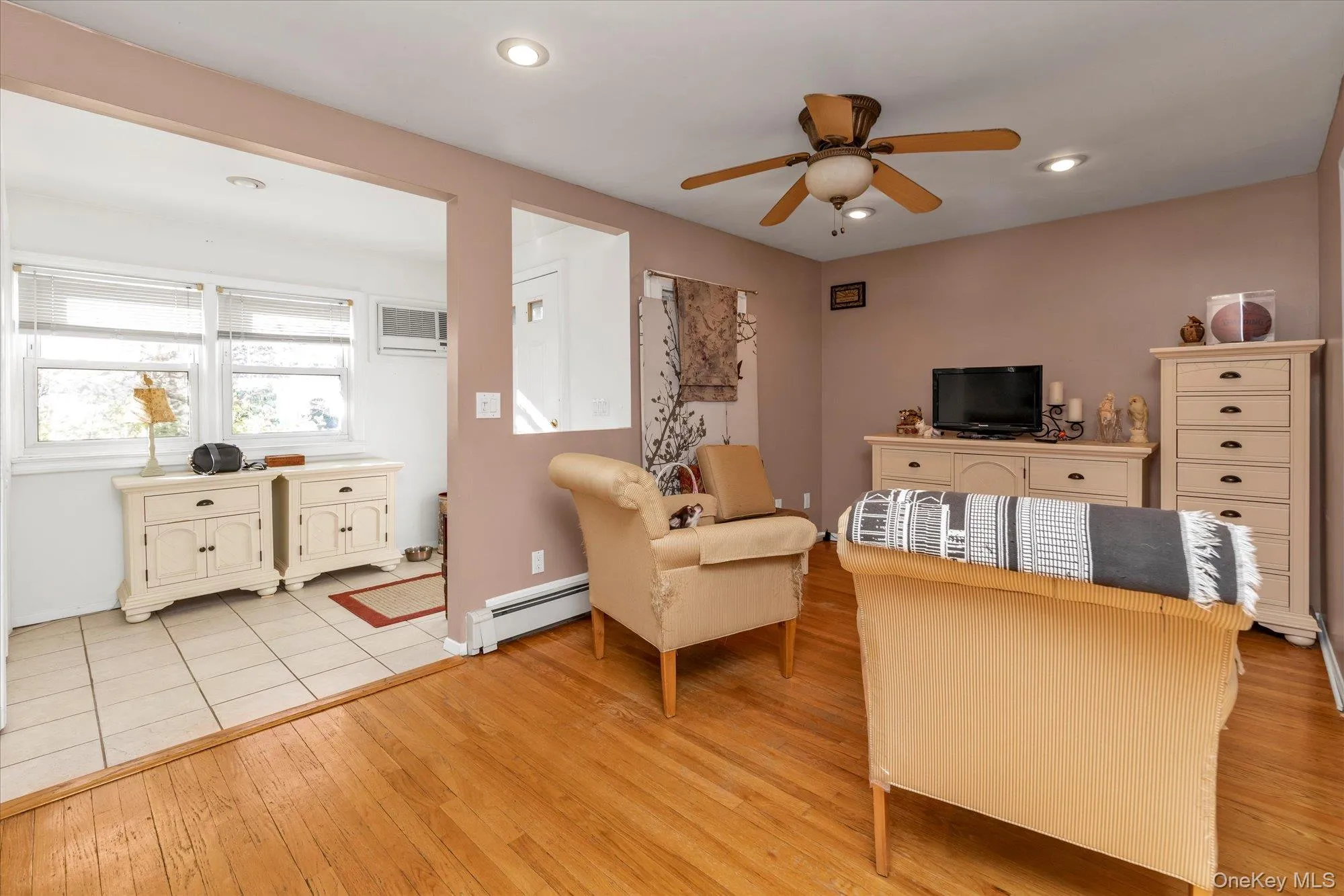 Office area with light wood-style flooring, a baseboard heating unit, ceiling fan, recessed lighting, and a wall mounted AC Office area with light wood-style flooring, a baseboard heating unit, ceiling fan, recessed lighting, and a wall mounted AC