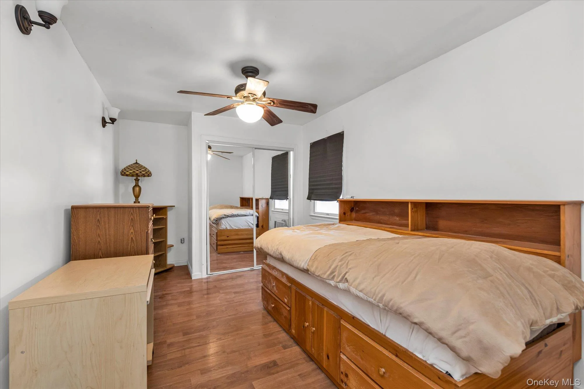 Bedroom with wood finished floors, ceiling fan, and a closet Bedroom with wood finished floors, ceiling fan, and a closet