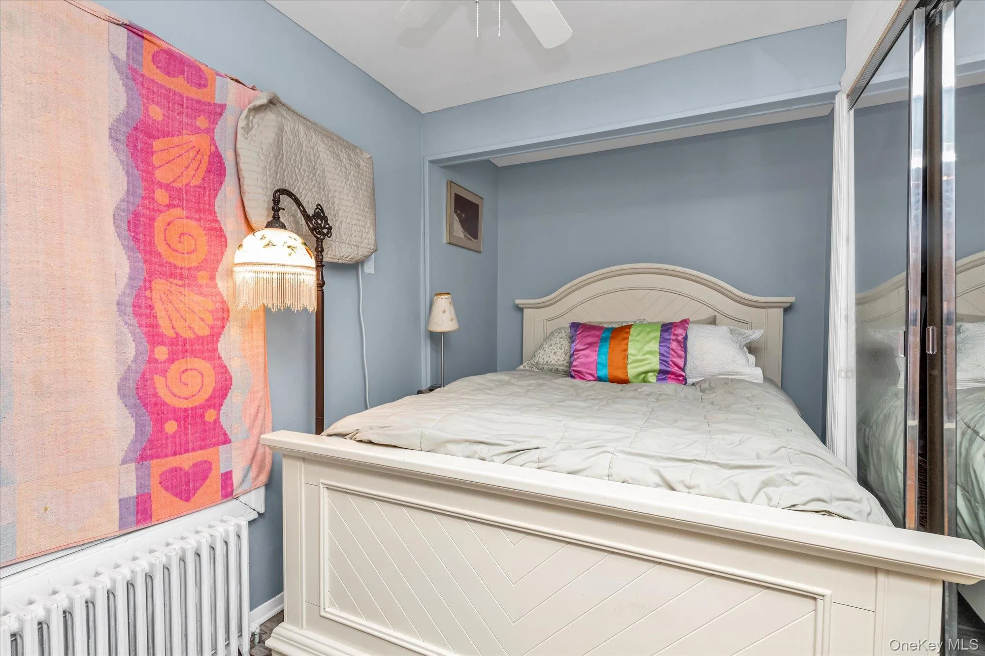 Bedroom featuring radiator heating unit and ceiling fan Bedroom featuring radiator heating unit and ceiling fan