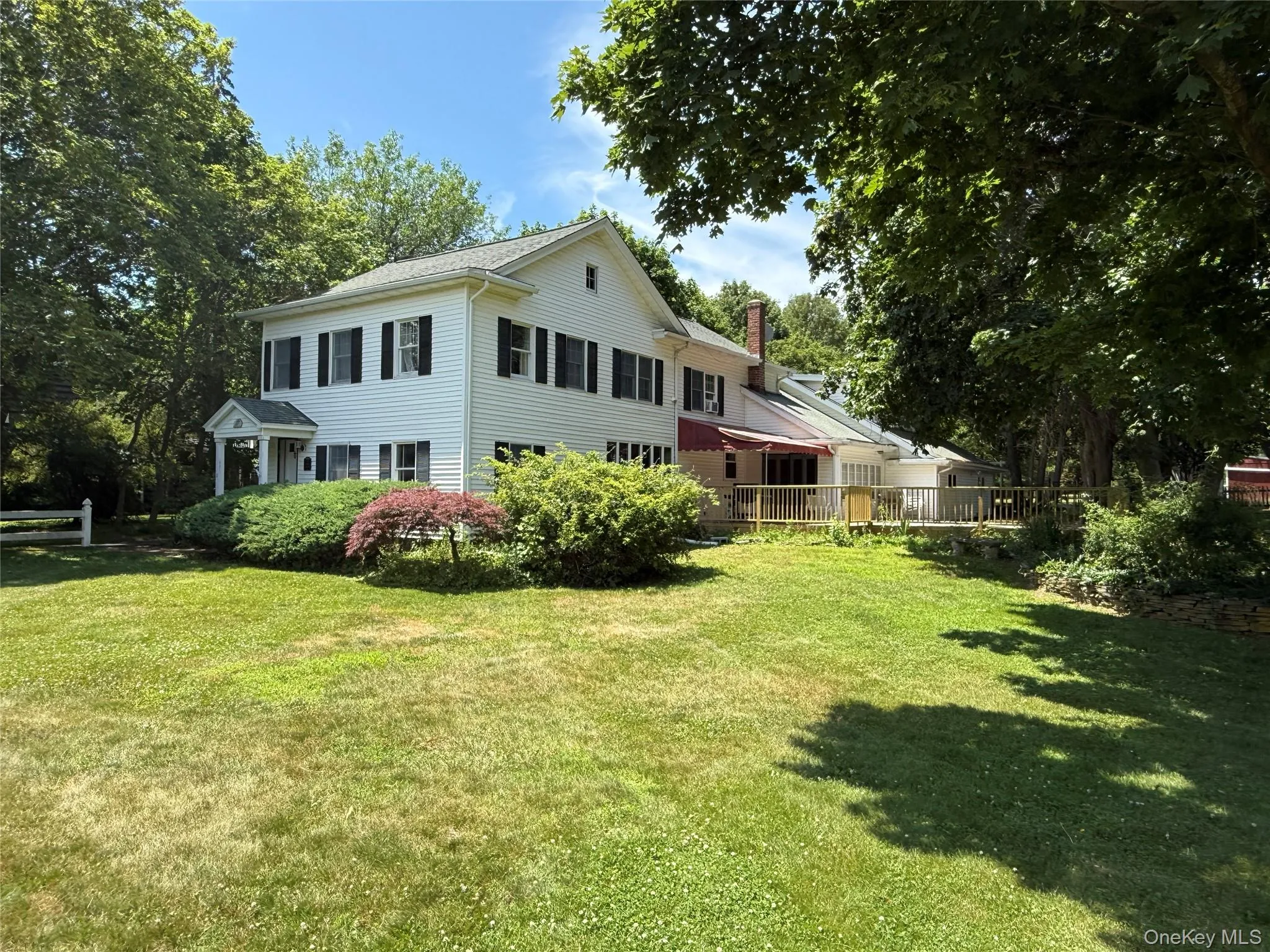 Back of property featuring a lawn and a chimney Back of property featuring a lawn and a chimney